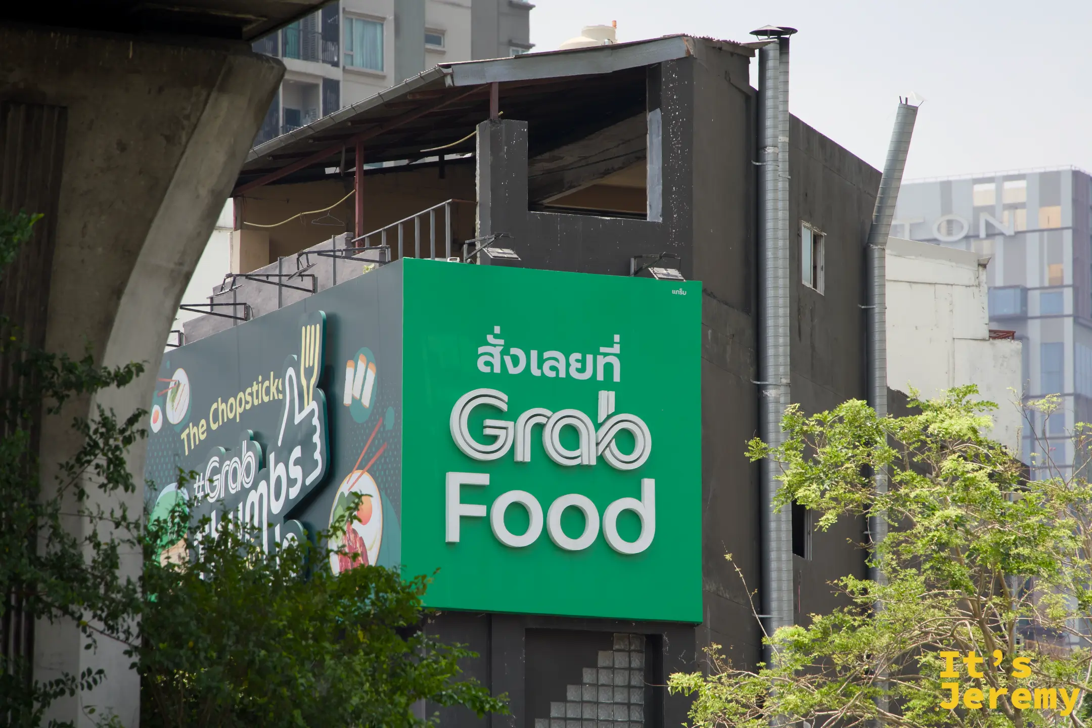 路旁的 GrabFood 廣告看板,綠色品牌色佔滿整個版面,在曼谷任何角落幾乎都能看到 Grab 的影子