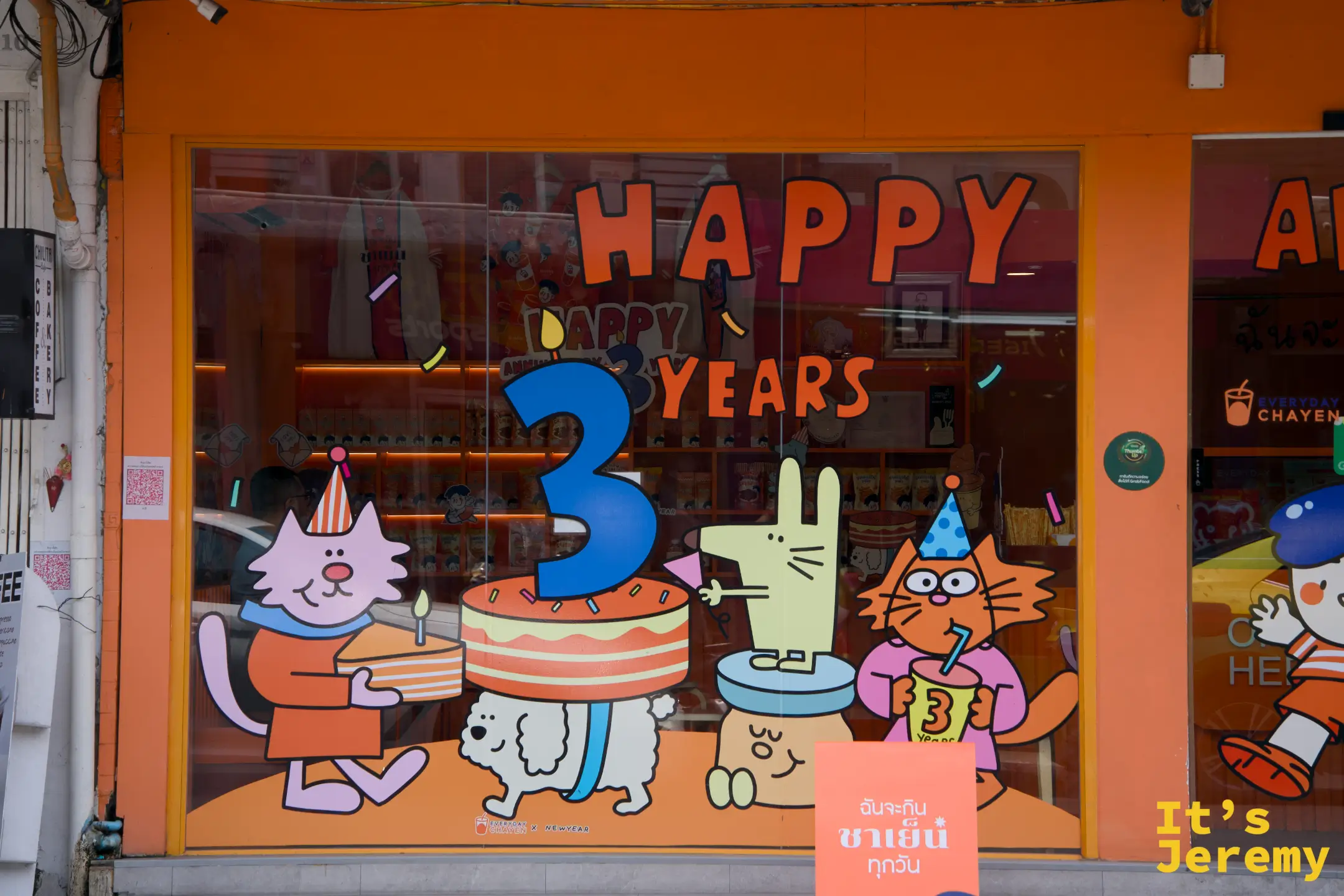 店窗玻璃貼著 Happy 3 Years 慶生插圖，貓、兔、小狗圍著生日蛋糕，充滿品牌插畫風格