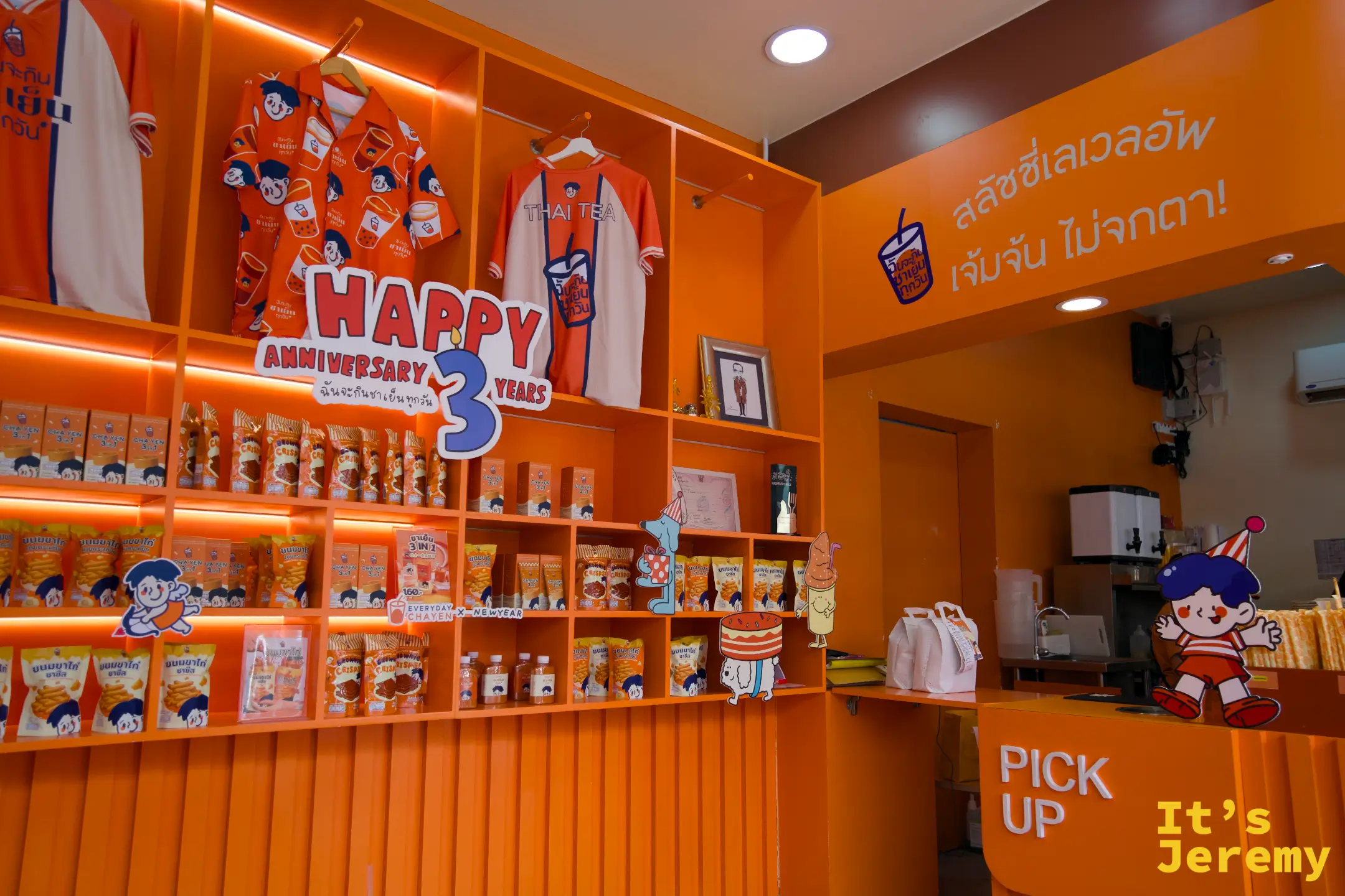 品牌展示架與 Pick Up 吧台的整體視角，牆上文字「สลัชซี่เลเวลอัพ เจ๋มจัน ไม่จกตา!」標示slushie選項