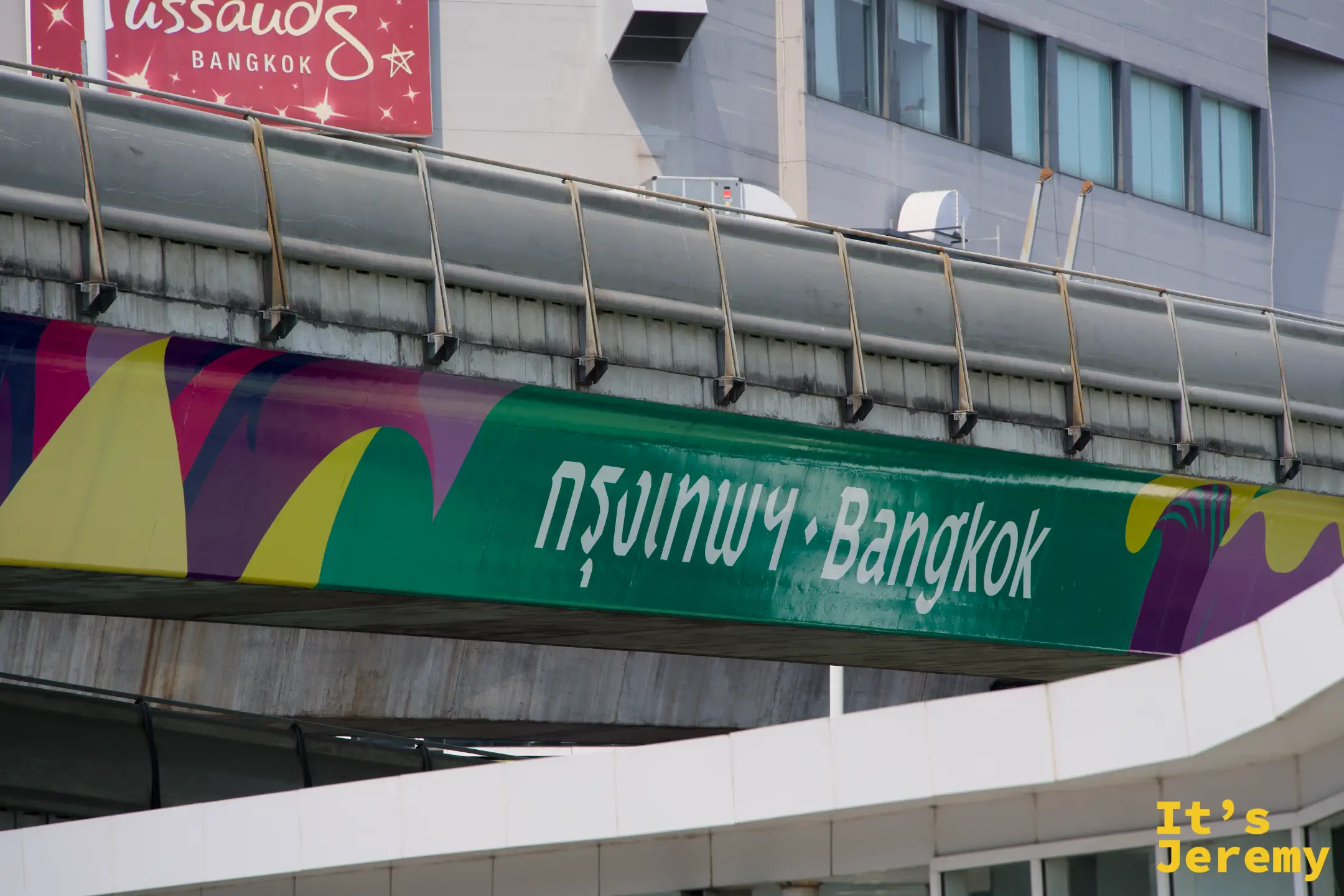 BTS 天橋上的方向指示牌,上頭印著「กรุงเทพ・Bangkok」金色字體,藍天做背景,字跡清晰