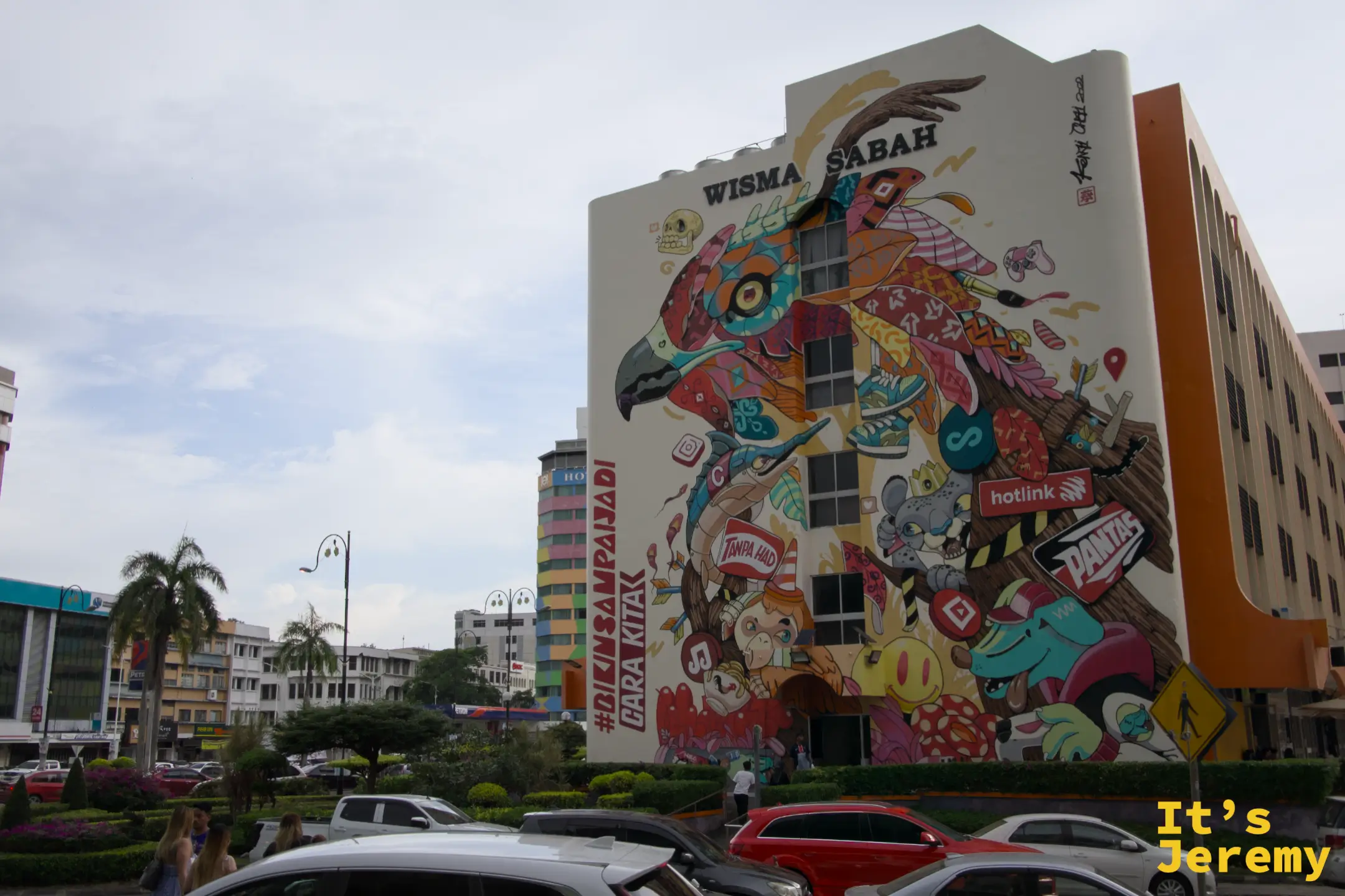 亞庇 Wisma Sabah 建築外牆大型彩繪壁畫，老鷹主題融合社群媒體符號與馬來元素