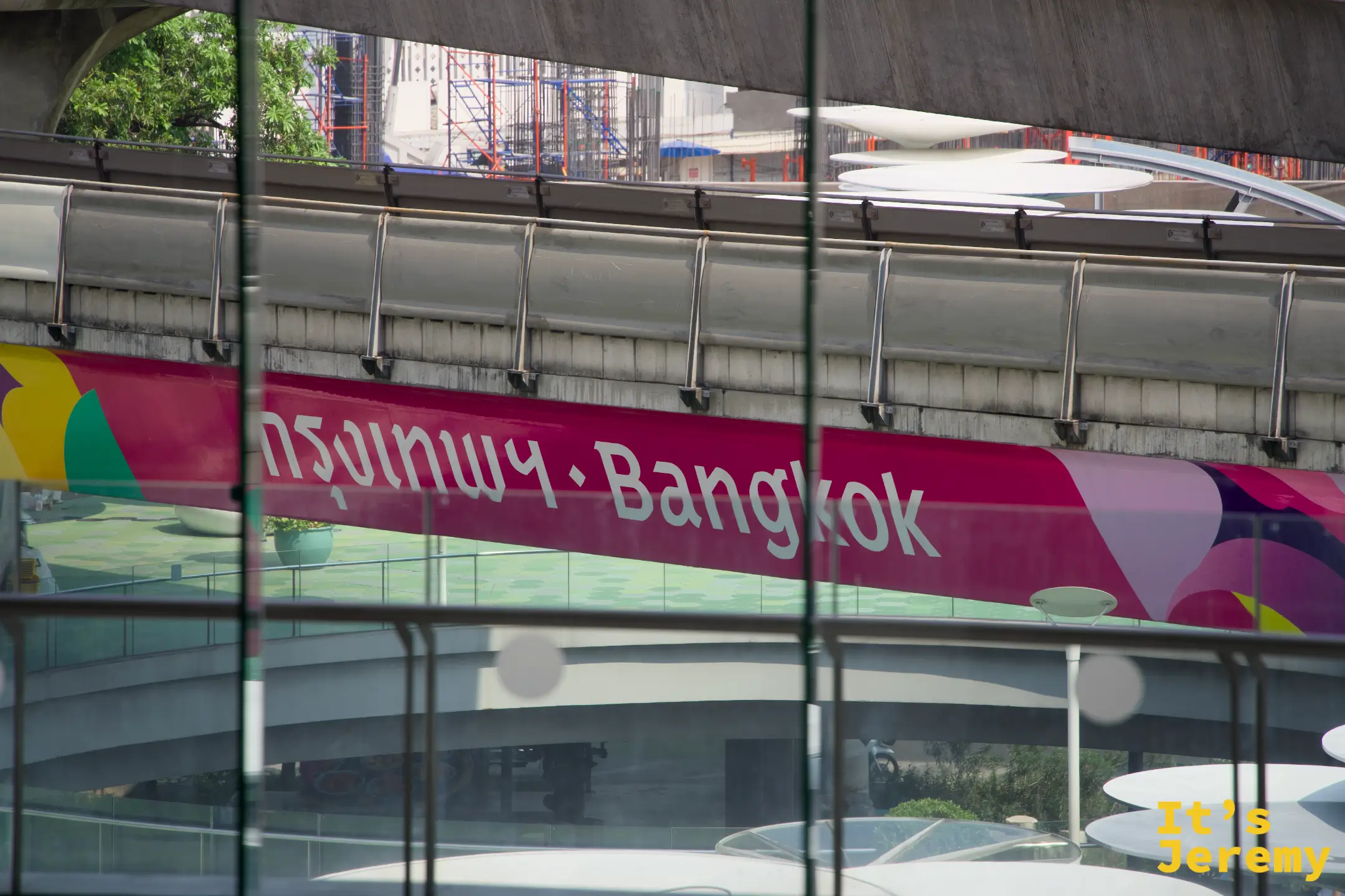 透過 BACC 玻璃帷幕看出去,「กรุงเทพ・Bangkok」的 BTS 捷運站牌清晰可見