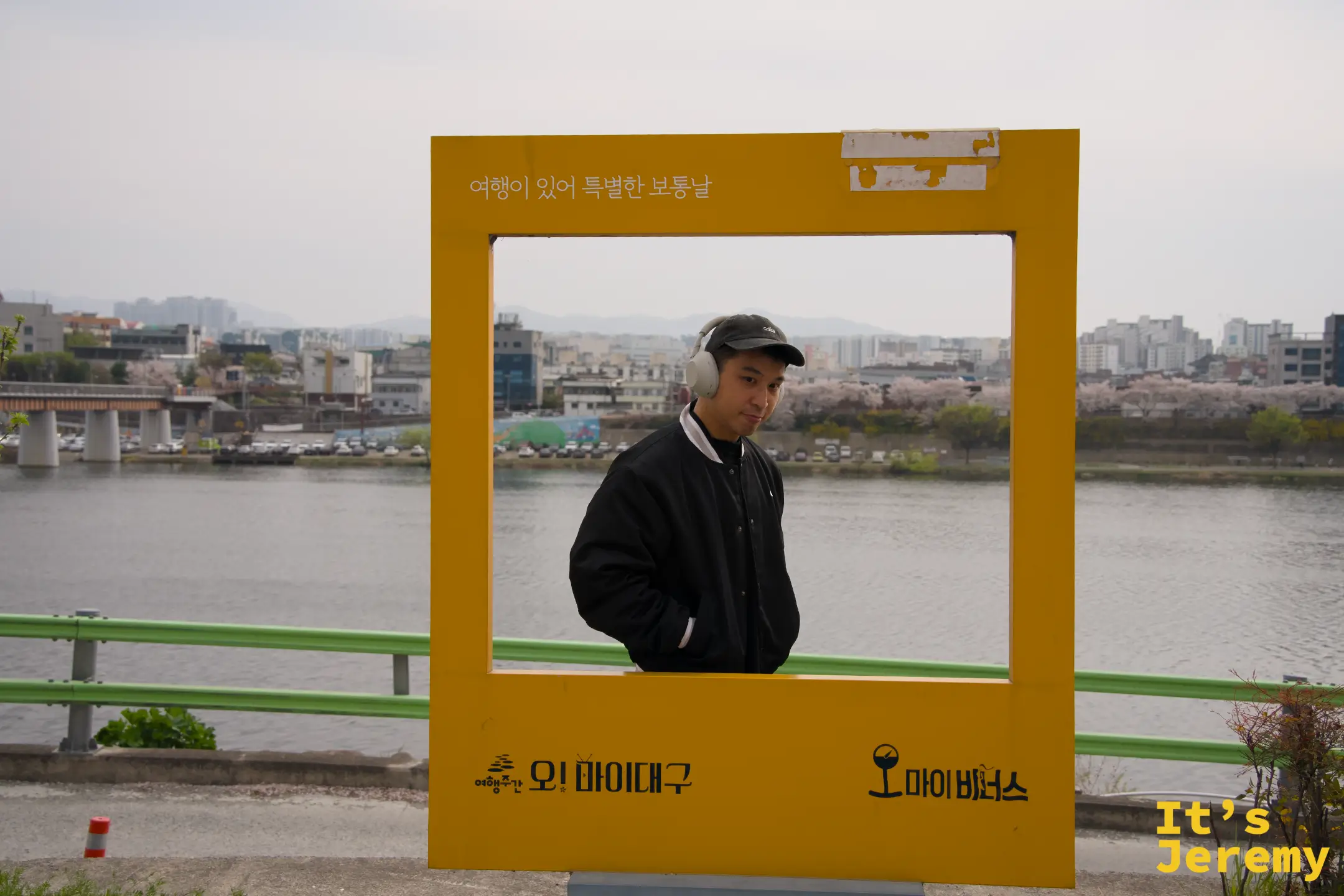 Jeremy 在「Oh My Daegu / 오 마이 비너스」橘色相框內拍照，背後是琴湖江與市區