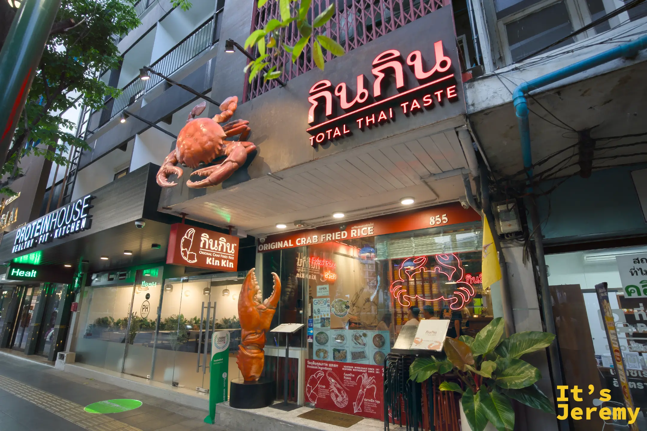 夜燈亮起的店頭全景，門口的巨型螃蟹雕塑搭著橘紅招牌，是 Sukhumvit 47 巷口最顯眼的地標