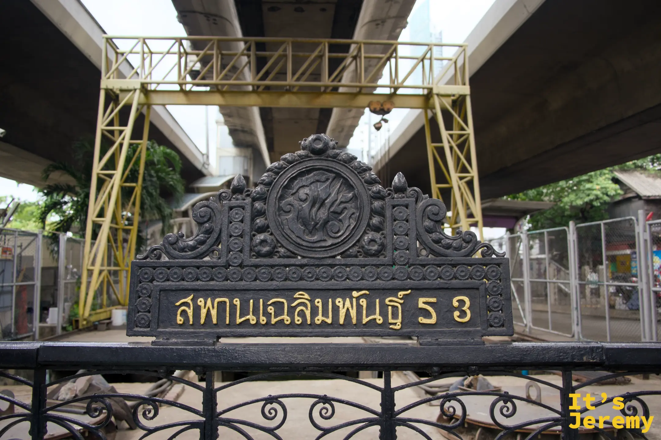 鑄鐵橋牌「สพานเฉลิมพันธ์ุ 53」,背後是 BTS 高架橋墩