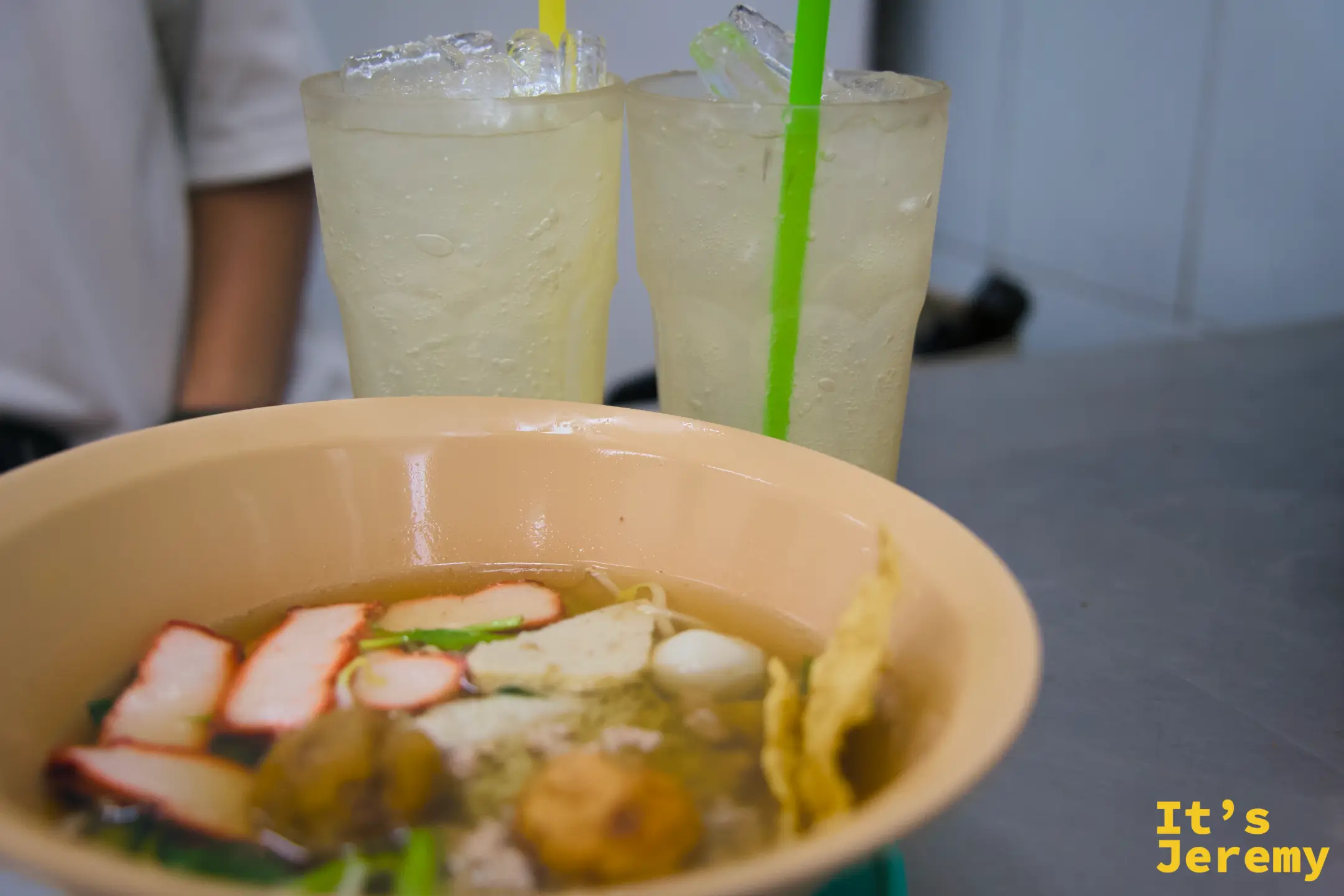桌面一碗清湯魚丸麵配兩杯淡黃色冰飲,搭出老麵攤最原始的用餐節奏