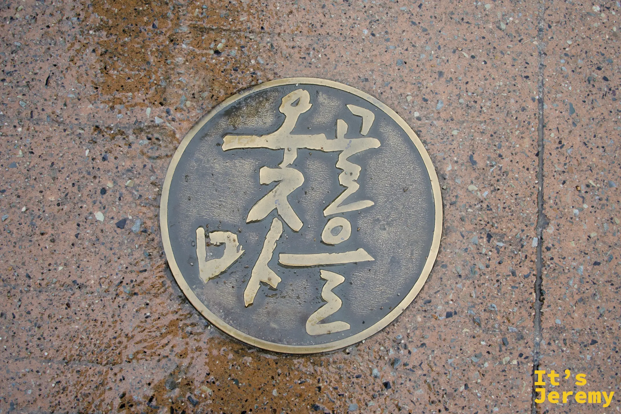 嵌在入口地板上的옻골마을圓形銅製徽章