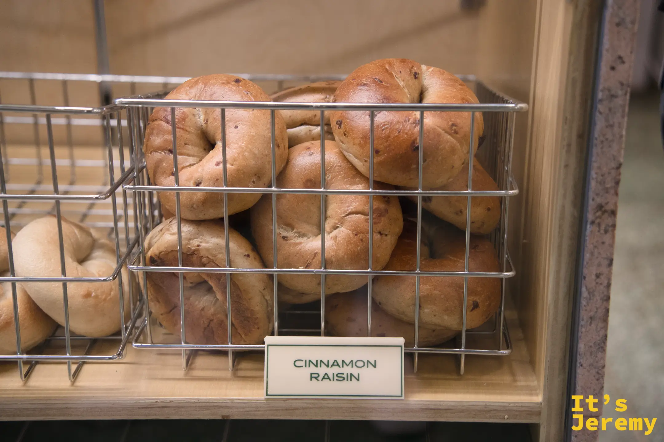Cinnamon Raisin 貝果堆疊在籃中,深棕色烤色,散發烤香