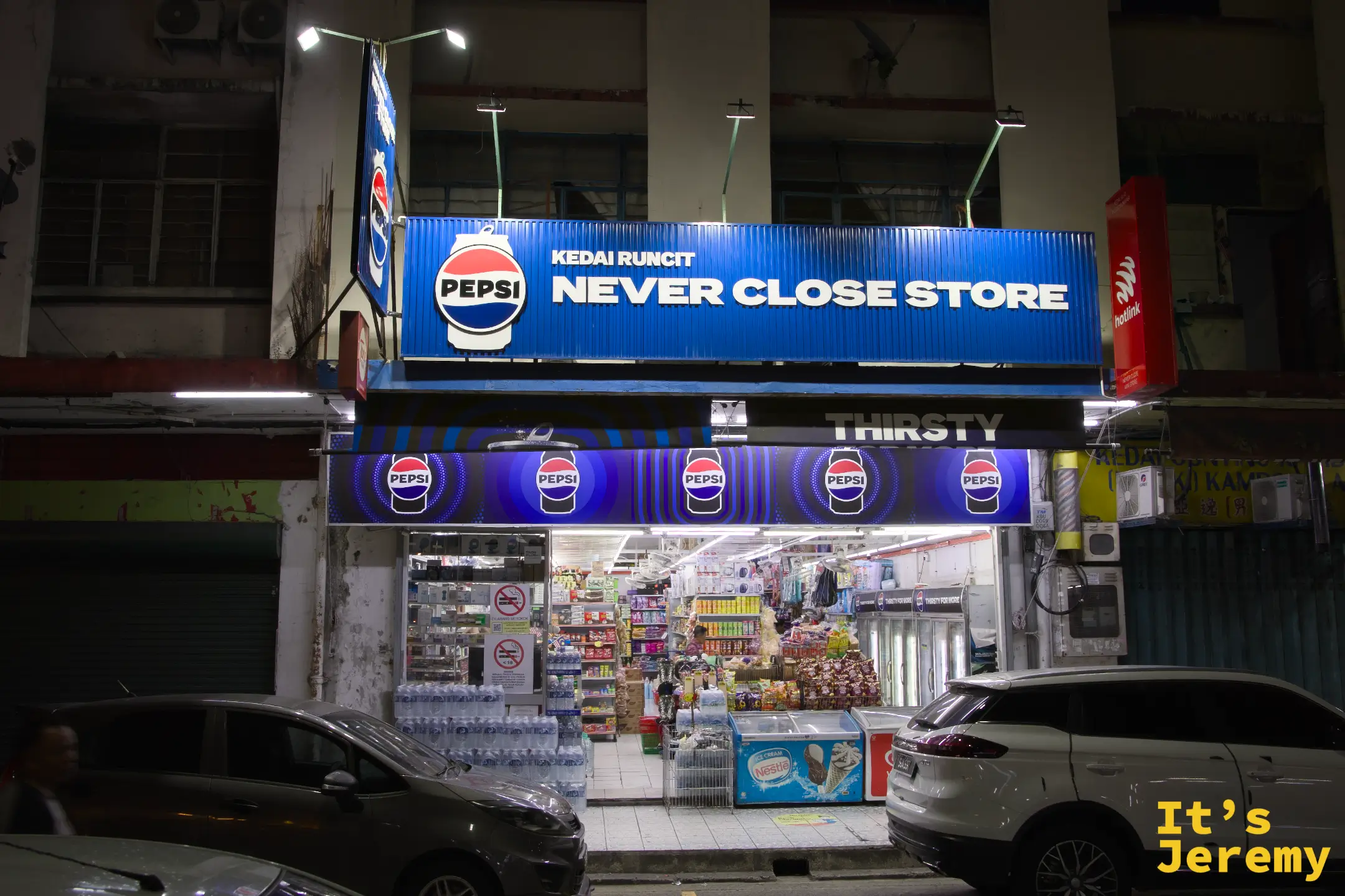 亞庇加雅街附近 Kedai Runcit「NEVER CLOSE STORE」24 小時便利商店，Pepsi 藍色霓虹燈箱外牆