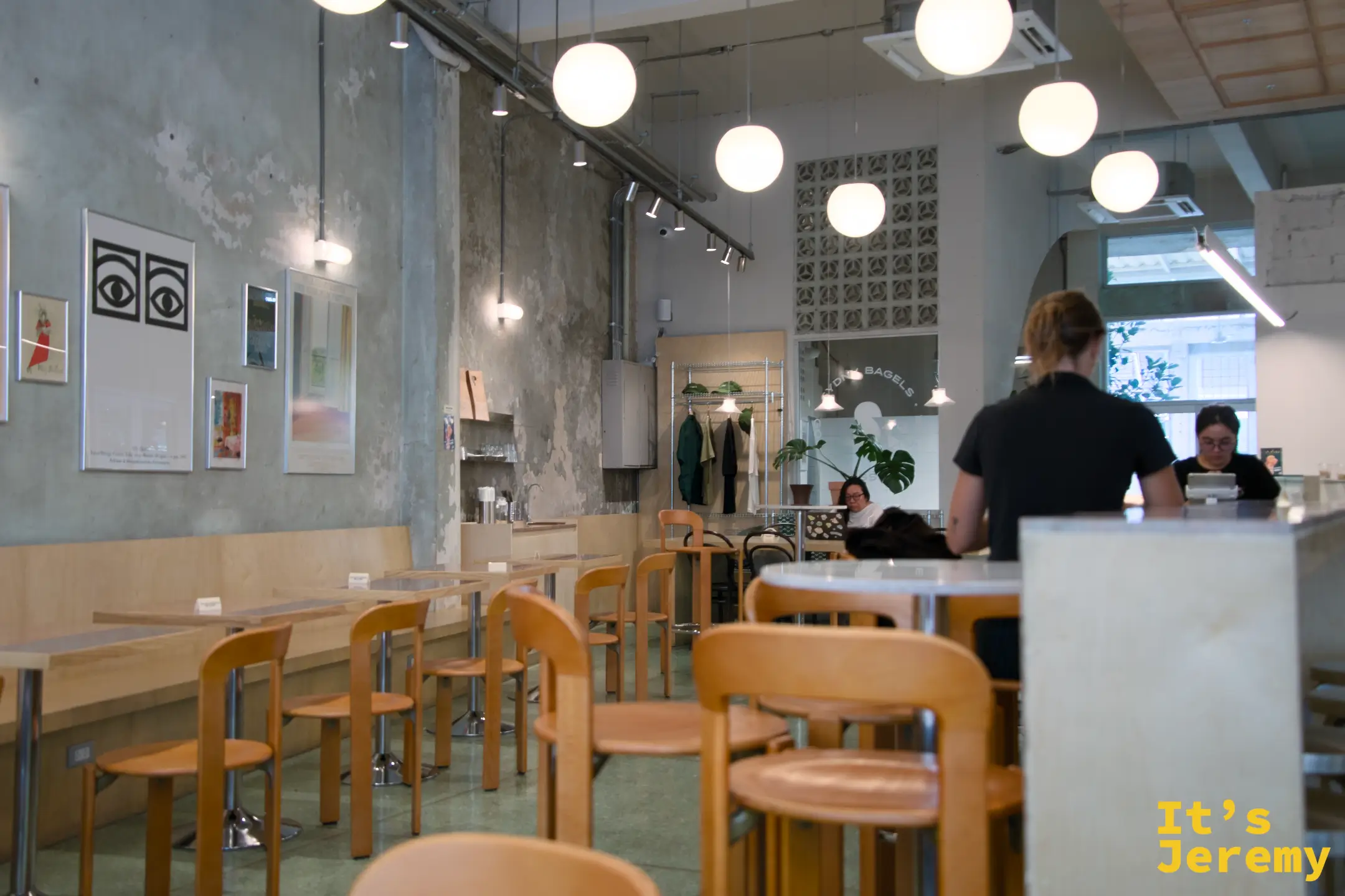 店內空間:橘色椅、球形吊燈、水泥質感牆面,牆上掛著藝術畫作,整體氛圍沉靜