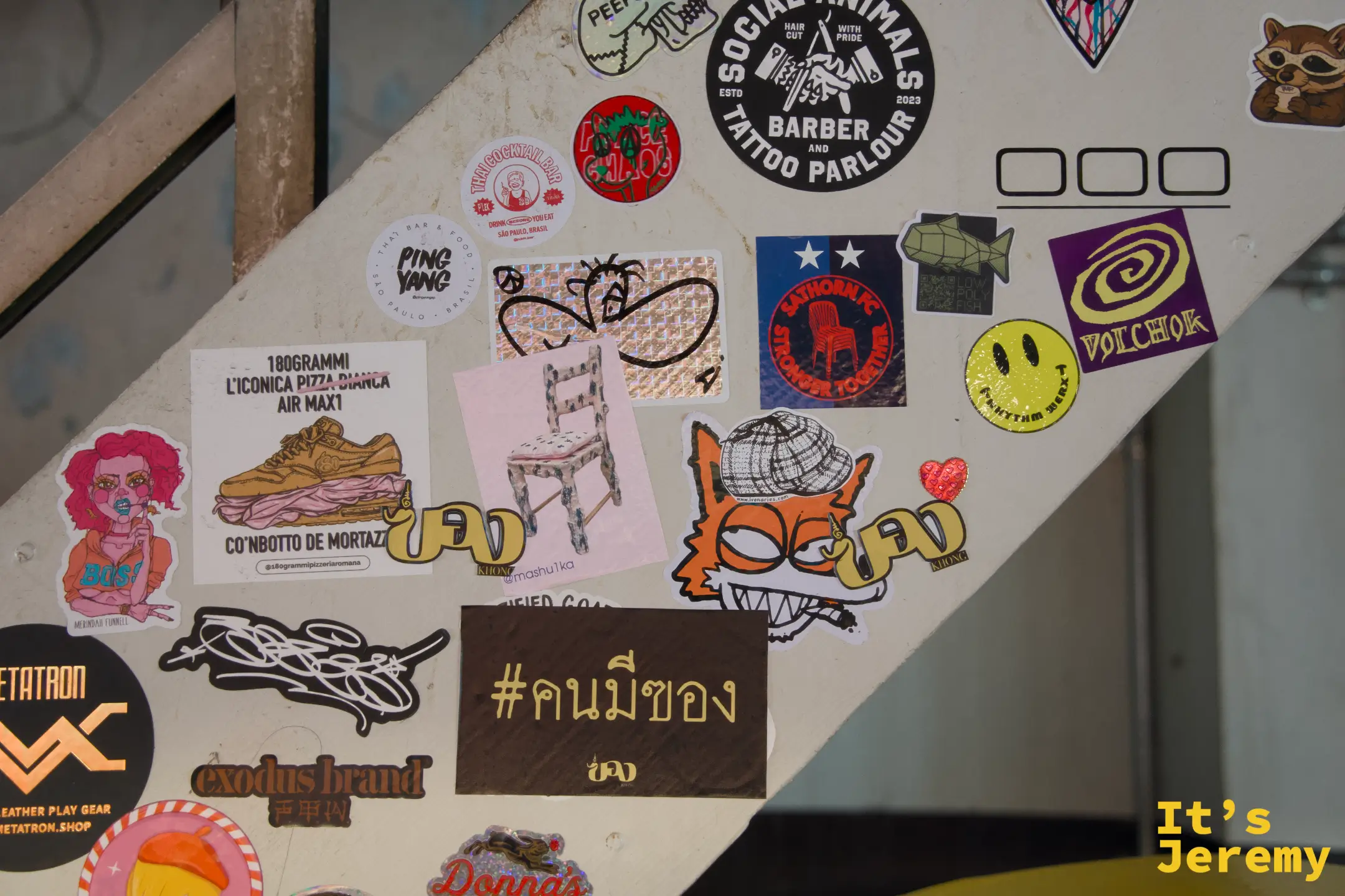 樓梯欄杆面密布貼紙:「Social Animals Barber & Tattoo Parlour」、「#คนมีของ」、各式插圖