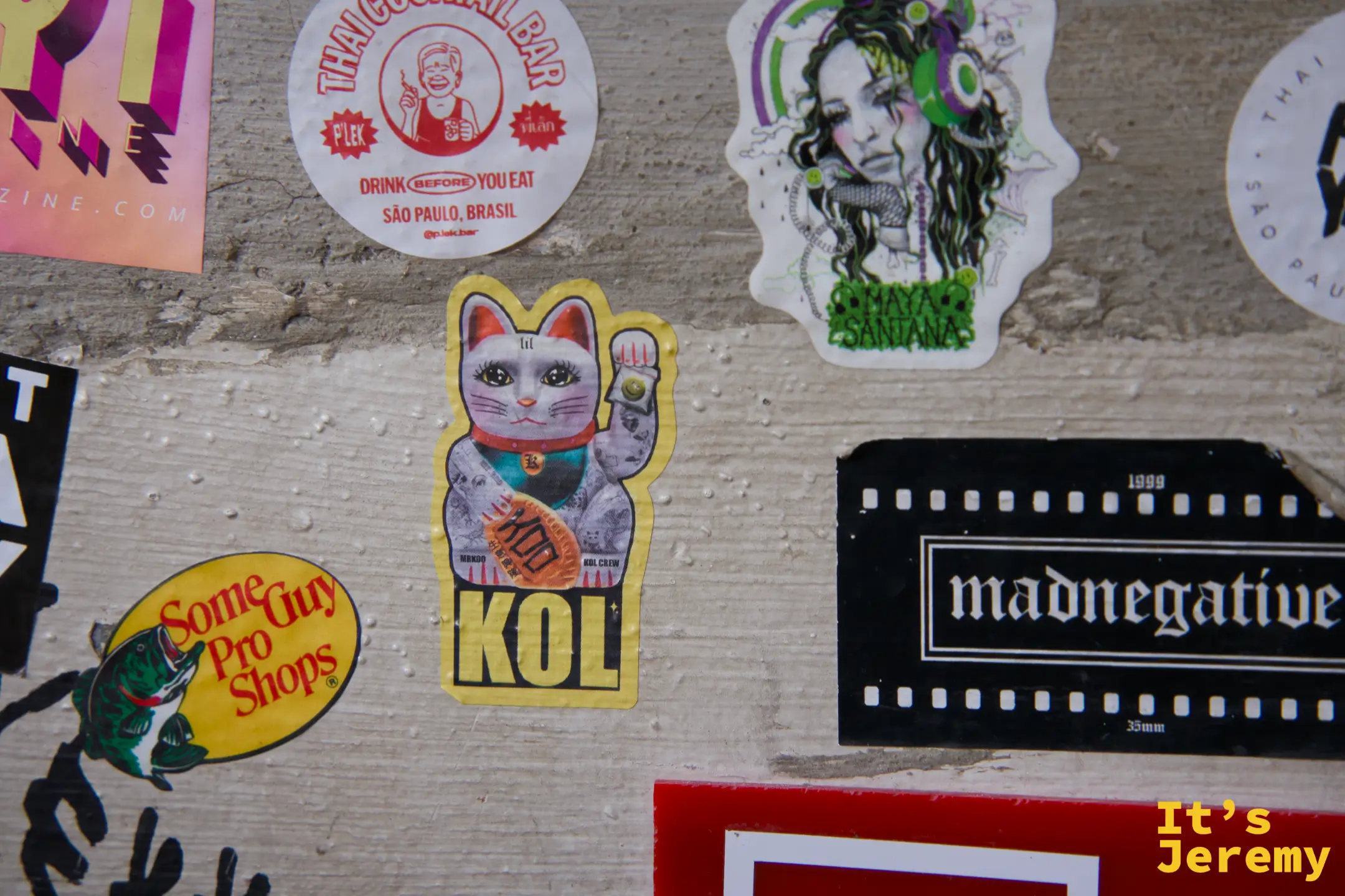 牆面特寫:KOL 招財貓貼紙、Thai Cocktail Bar 貼紙、madnegative 膠卷框貼紙