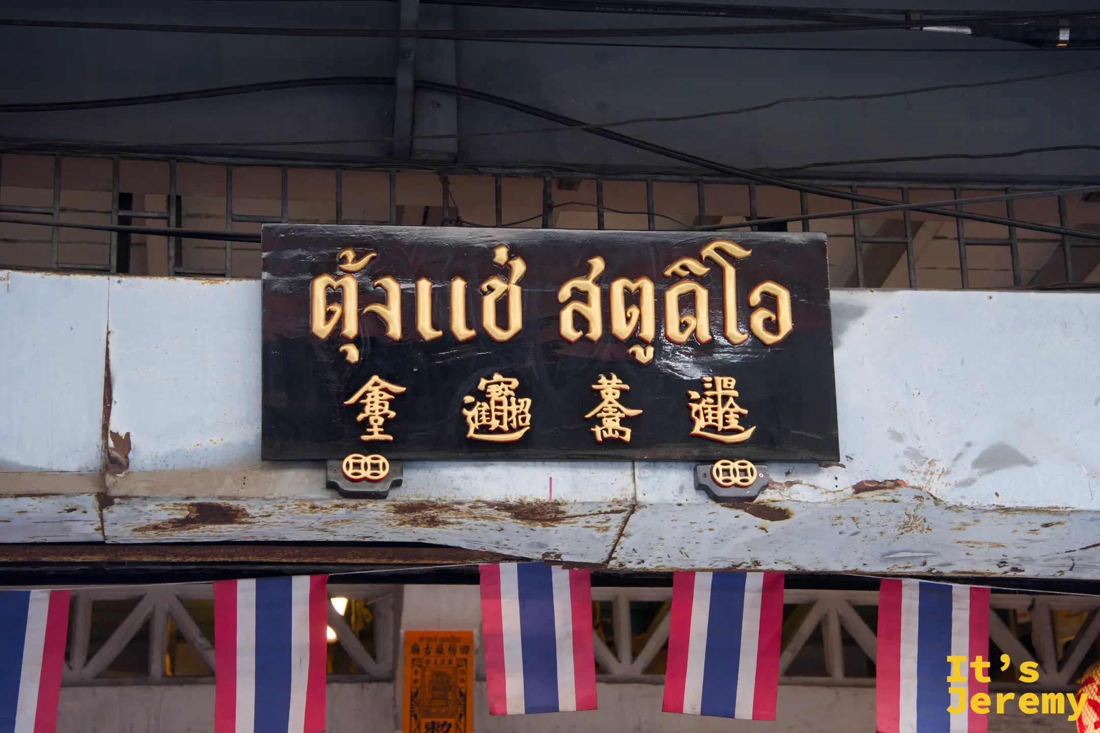 「ตั้งแช่ สตูดิโอ」黑底金字雕刻招牌，泰文與漢字並列，老廣東商號字體風格