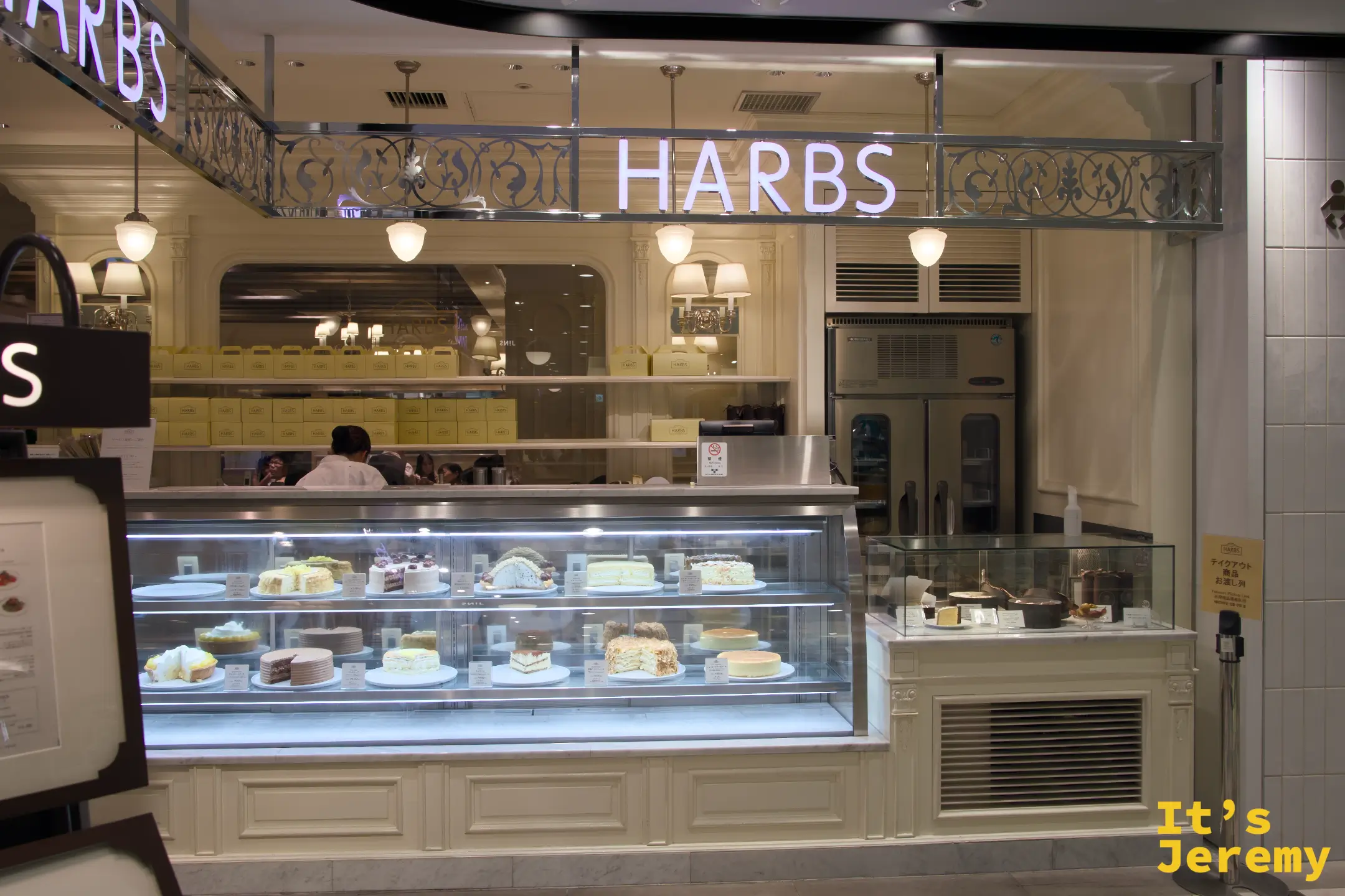 另一個角度的 HARBS 展示台，標牌清晰，蛋糕品項一目了然