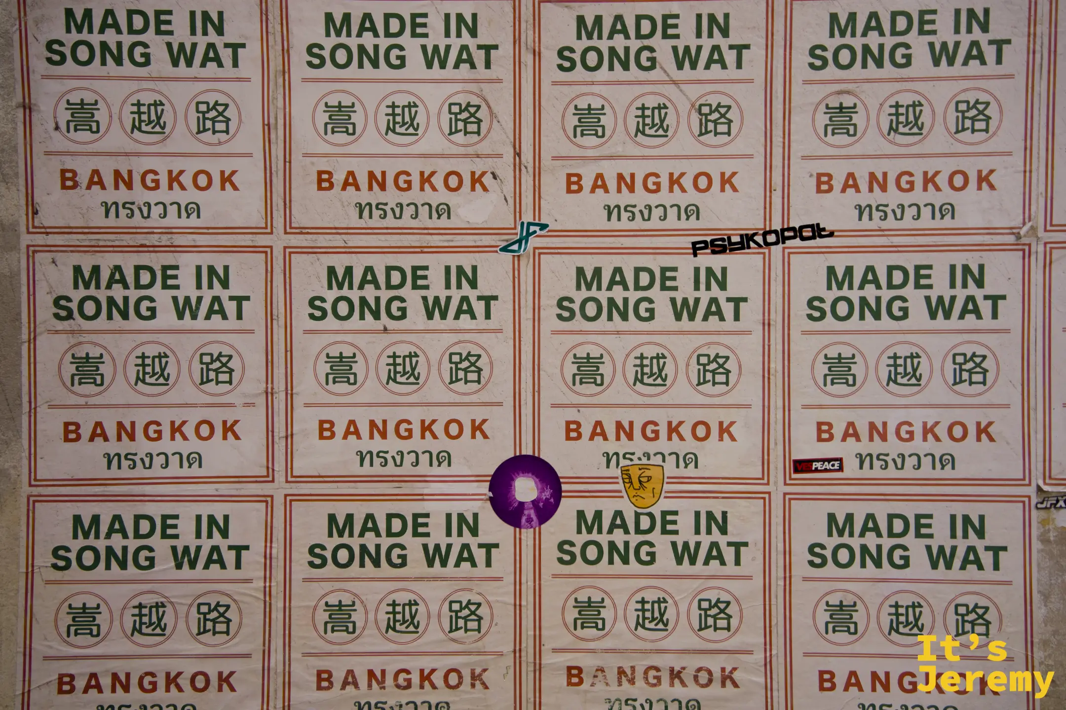 整面牆鋪滿「MADE IN SONG WAT 嵩越路 BANGKOK ทรงวาด」方形貼紙，整齊排列如海關標章
