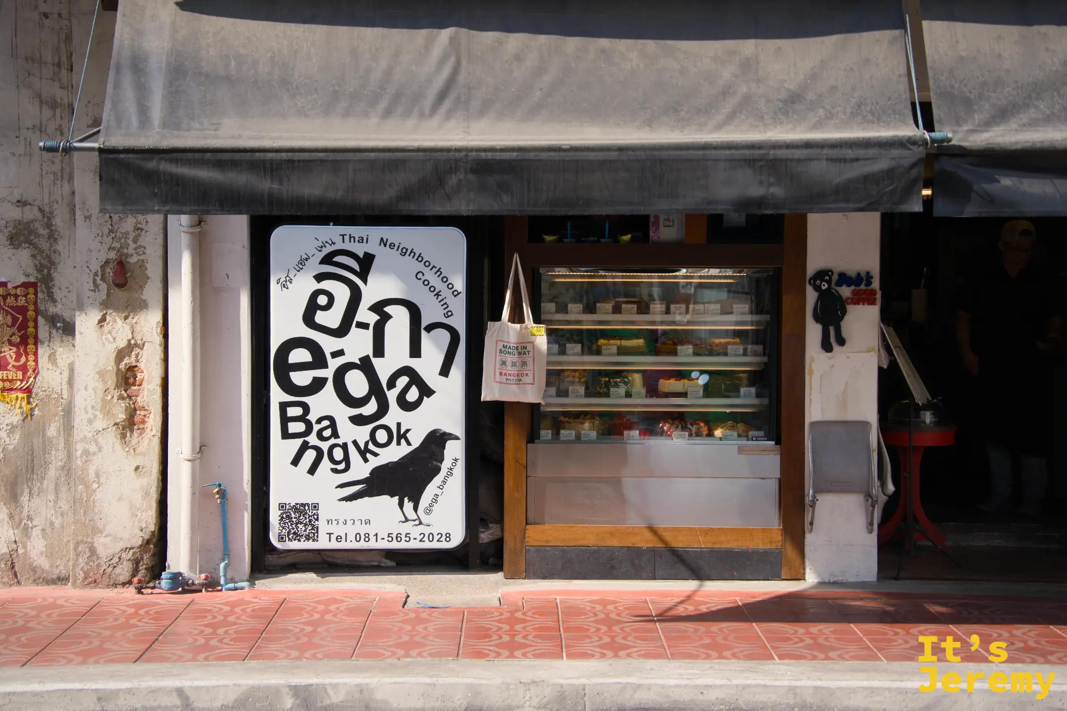 「อีกา e·ga Bangkok Thai Neighborhood Cooking」餐廳外觀：黑烏鴉招牌、食材展示冰台，掛著「MADE IN SONG WAT」帆布袋