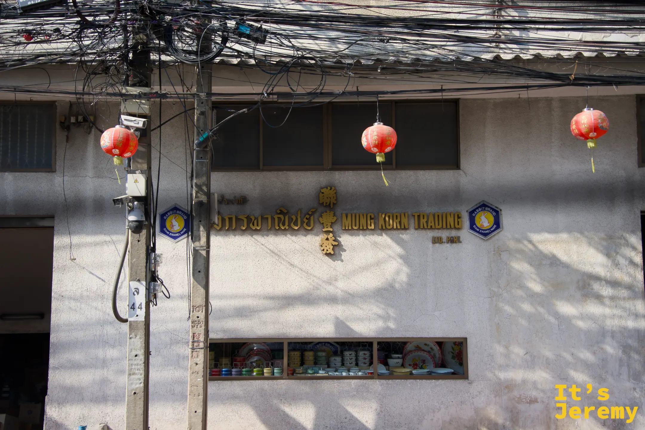 「聯豐 Mung Korn Trading 益商號」百年老建築立面，窗台陳列彩色搪瓷碗盤，兩側掛著橘紅燈籠