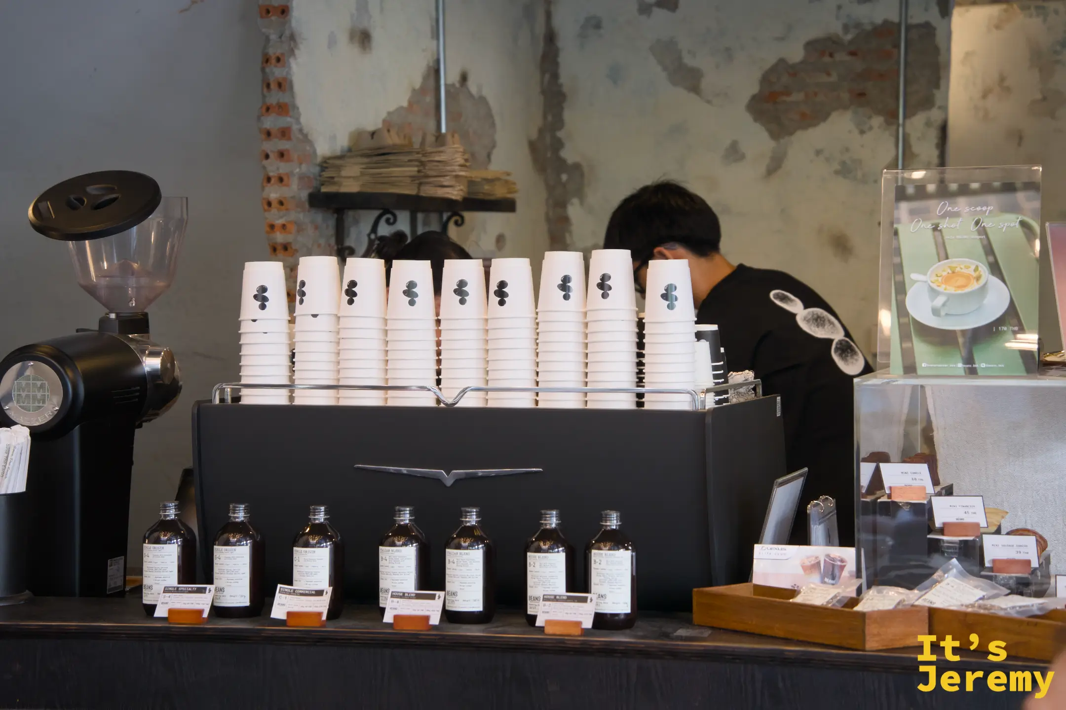 吧台後場:Slayer 咖啡機與整排白色紙杯、咖啡師專注備料,右側可見特飲展示卡