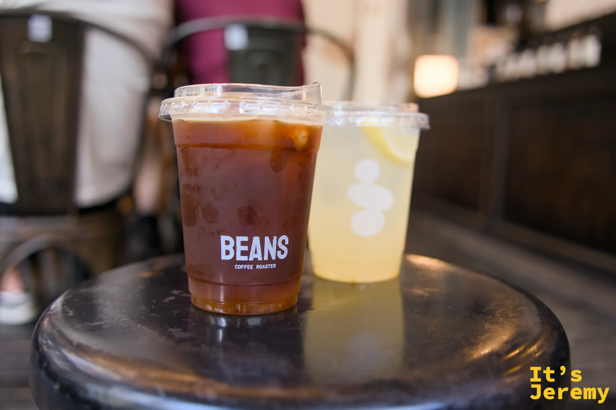 桌上兩杯:左為深棕色 Songwat Blend,右為淡黃色 Yuzu Soda,可見柚子切片沉於杯底