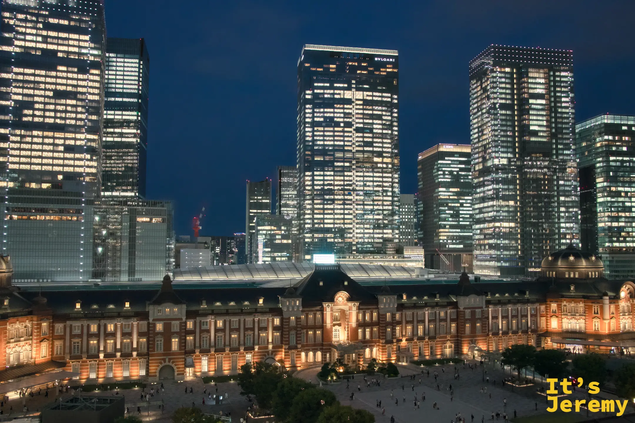 深夜全幅橫景，東京車站橘光點燈，丸之內摩天大樓群各自散發藍白色辦公室燈光