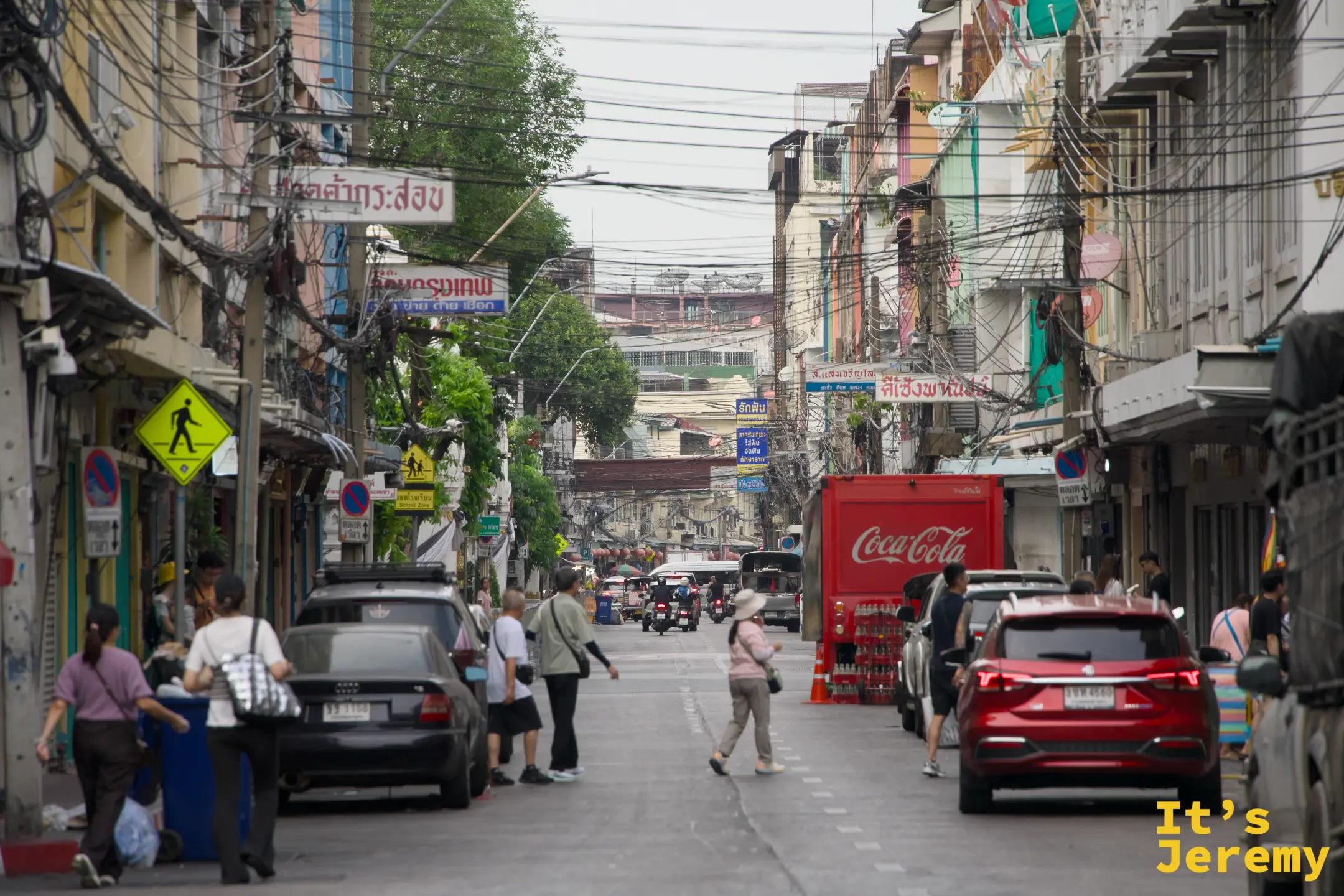 嵩越路巷口,Coca-Cola 紅色大卡車擠進窄巷,兩側老建築,行人閃讓