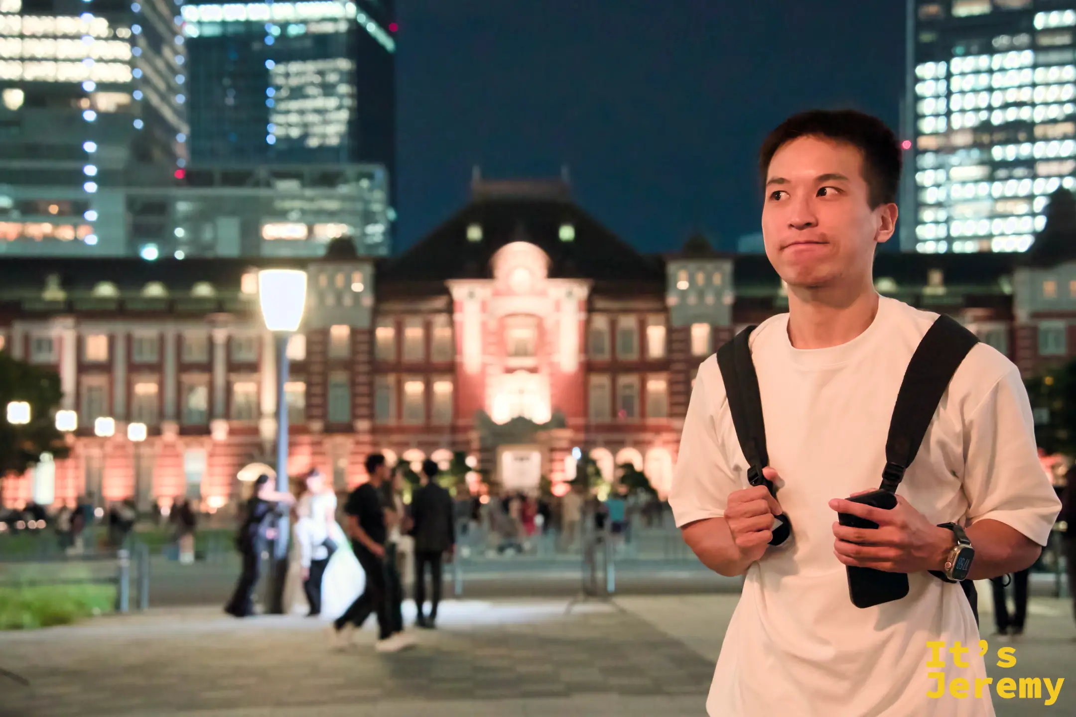 Jeremy 站在廣場，橘紅燈光下的東京車站在身後清晰展開