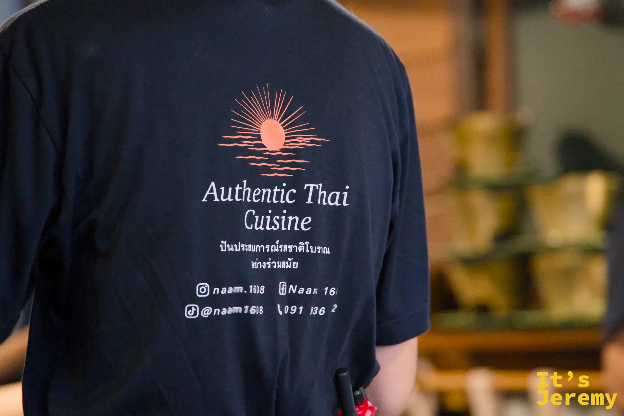 服務員背影,T-shirt 後背清楚印著「Authentic Thai Cuisine」字樣