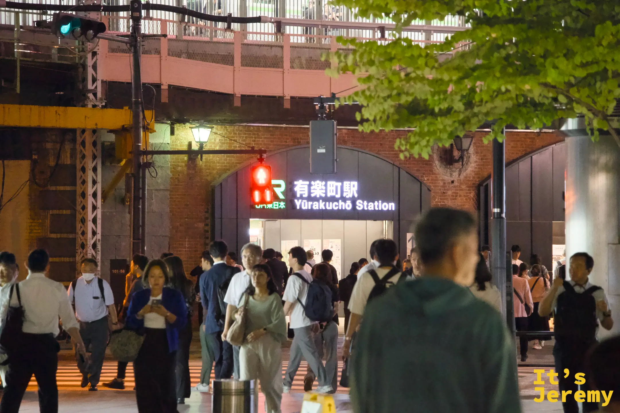 入夜的東京國際論壇廣場附近,JR 有楽町駅的紅磚高架橋底下,人群在站前聚集等待