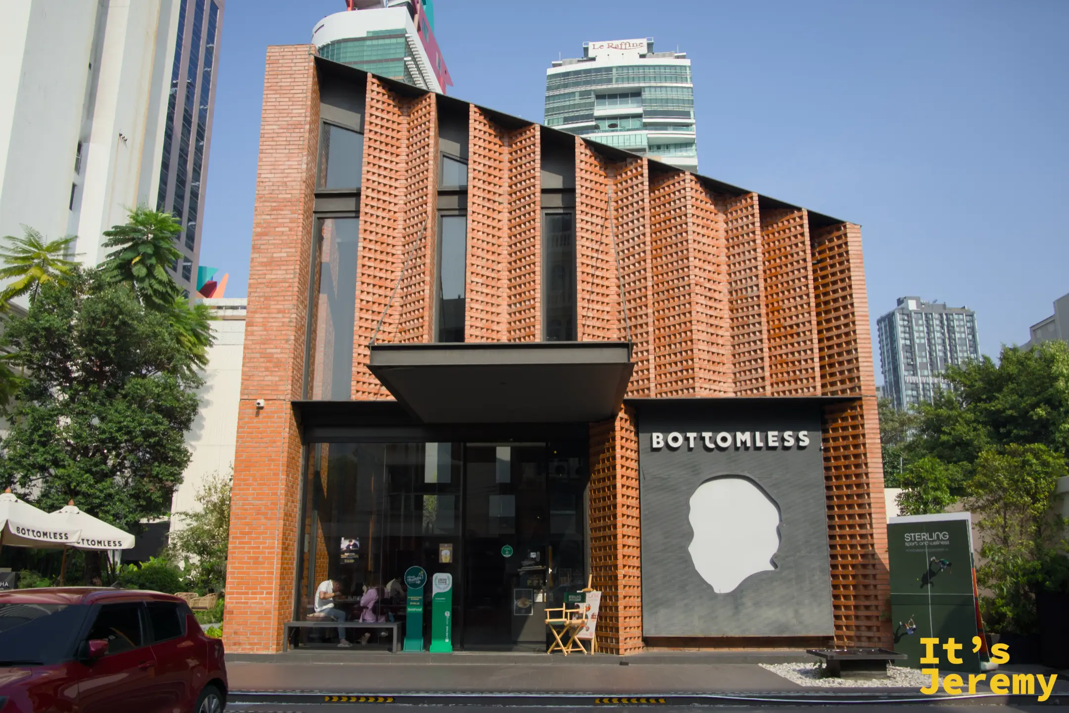 BOTTOMLESS 入口正面全景，左側大門，右側大型人頭 logo 牆