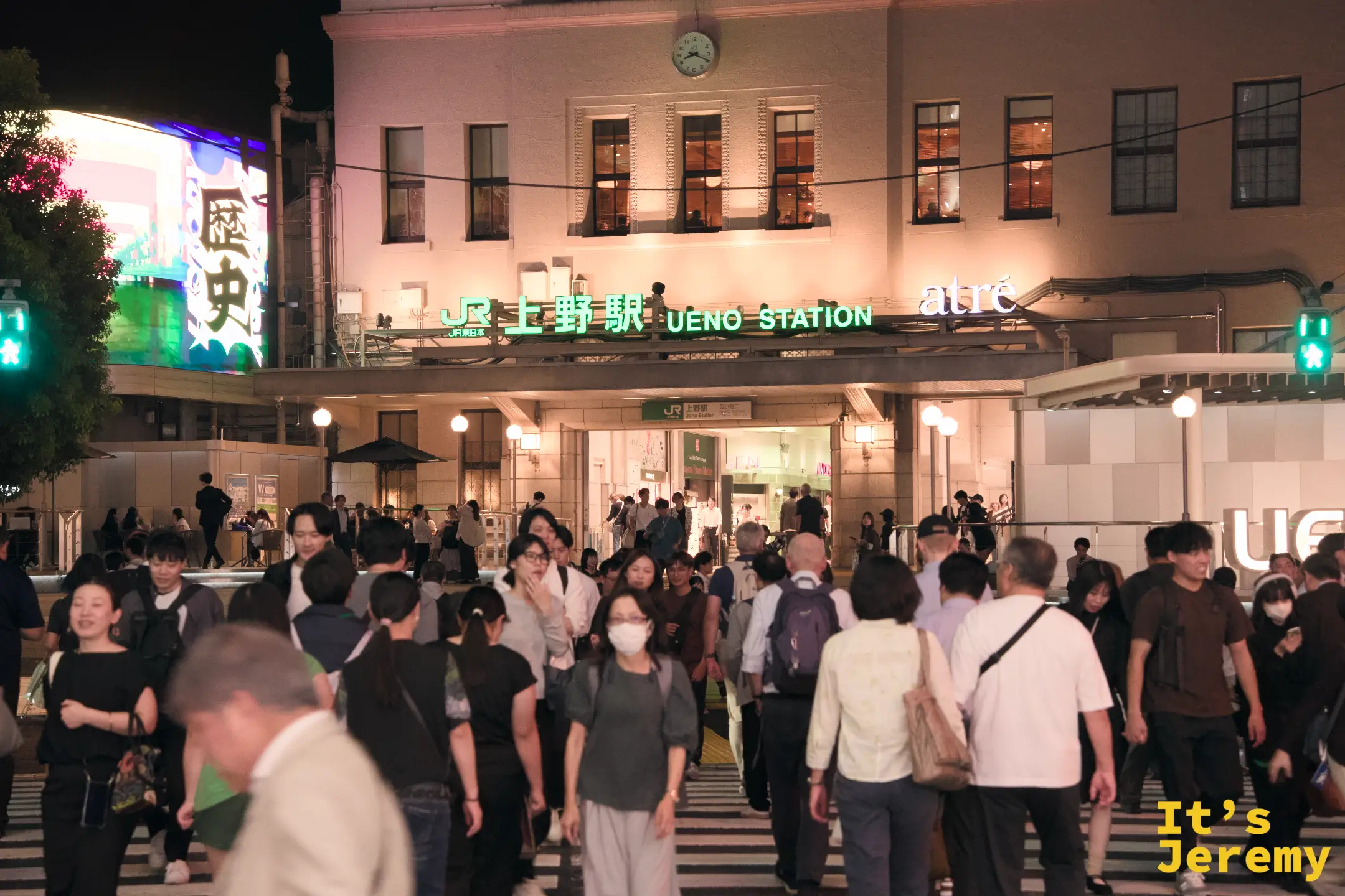 上野駅前斑馬線上的人群,JR 上野駅 UENO STATION 招牌與入口全景清晰可見,人潮往各自的方向散去