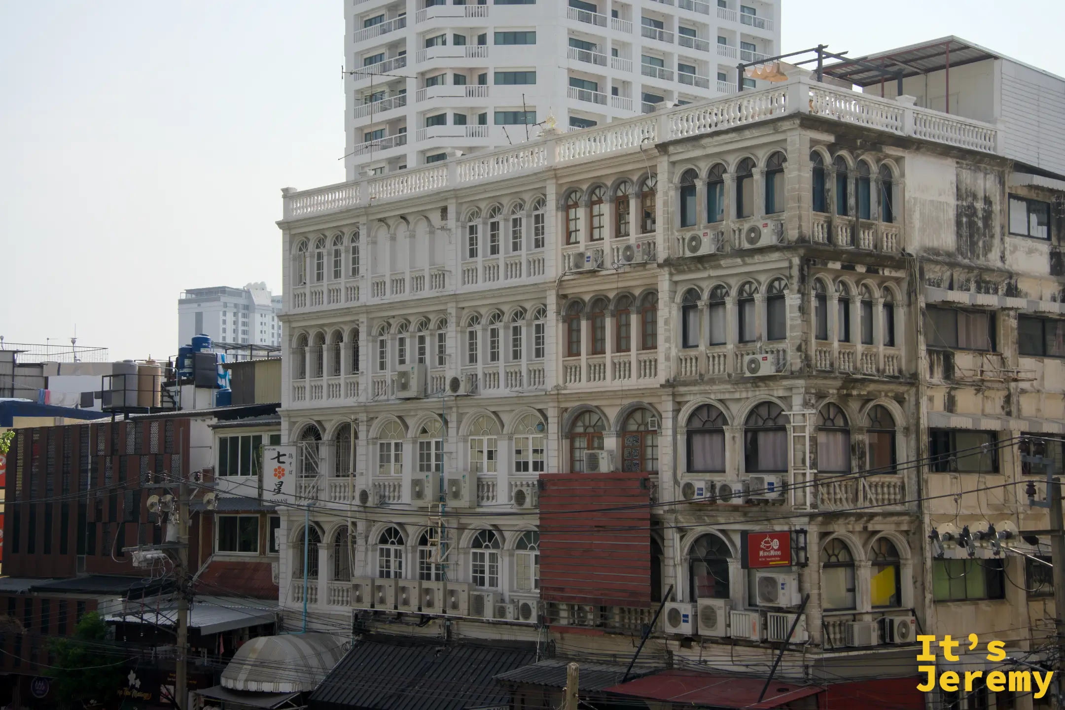 從三樓天台望向對街，可見白色歐式殖民風格舊建築多層拱窗