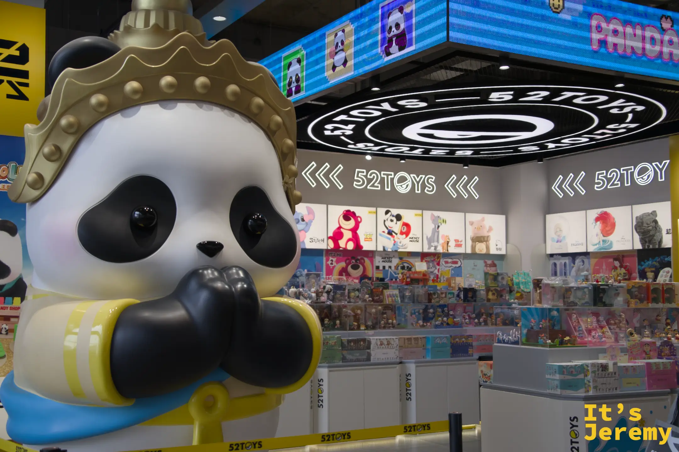 52TOYS 潮玩店,門口巨型熊貓戴泰式金冠雕塑,店內背景是 LED 螢幕和各式盲盒