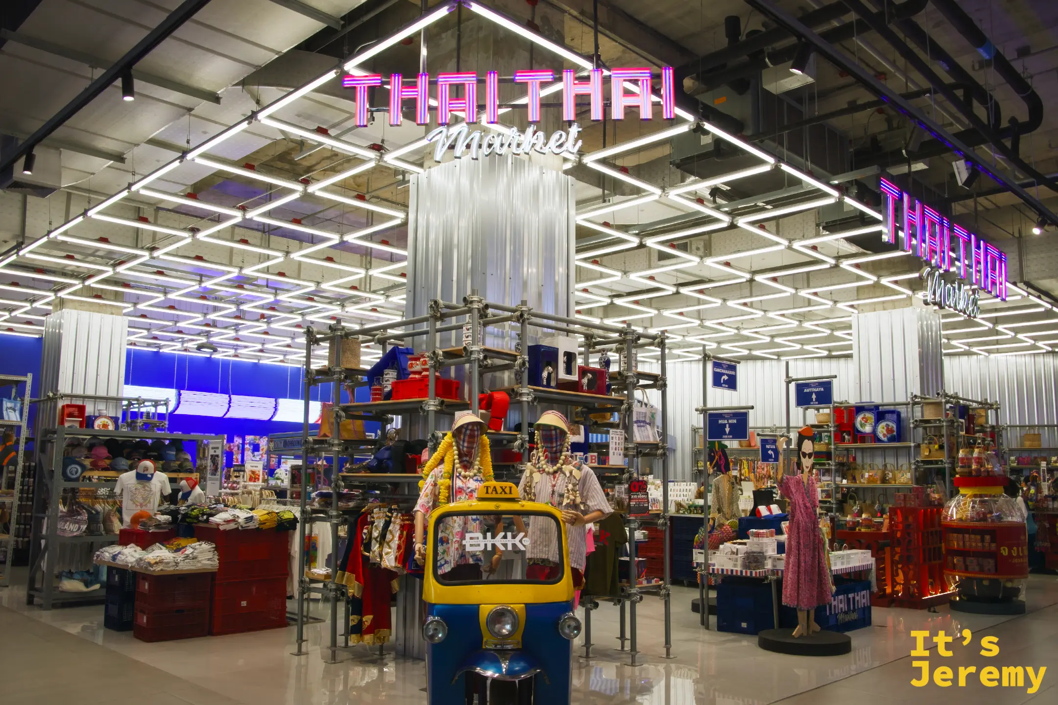 Thai Thai Market 入口全景,霓虹燈管招牌,嘟嘟車裝飾,兩側假人穿著泰式服裝