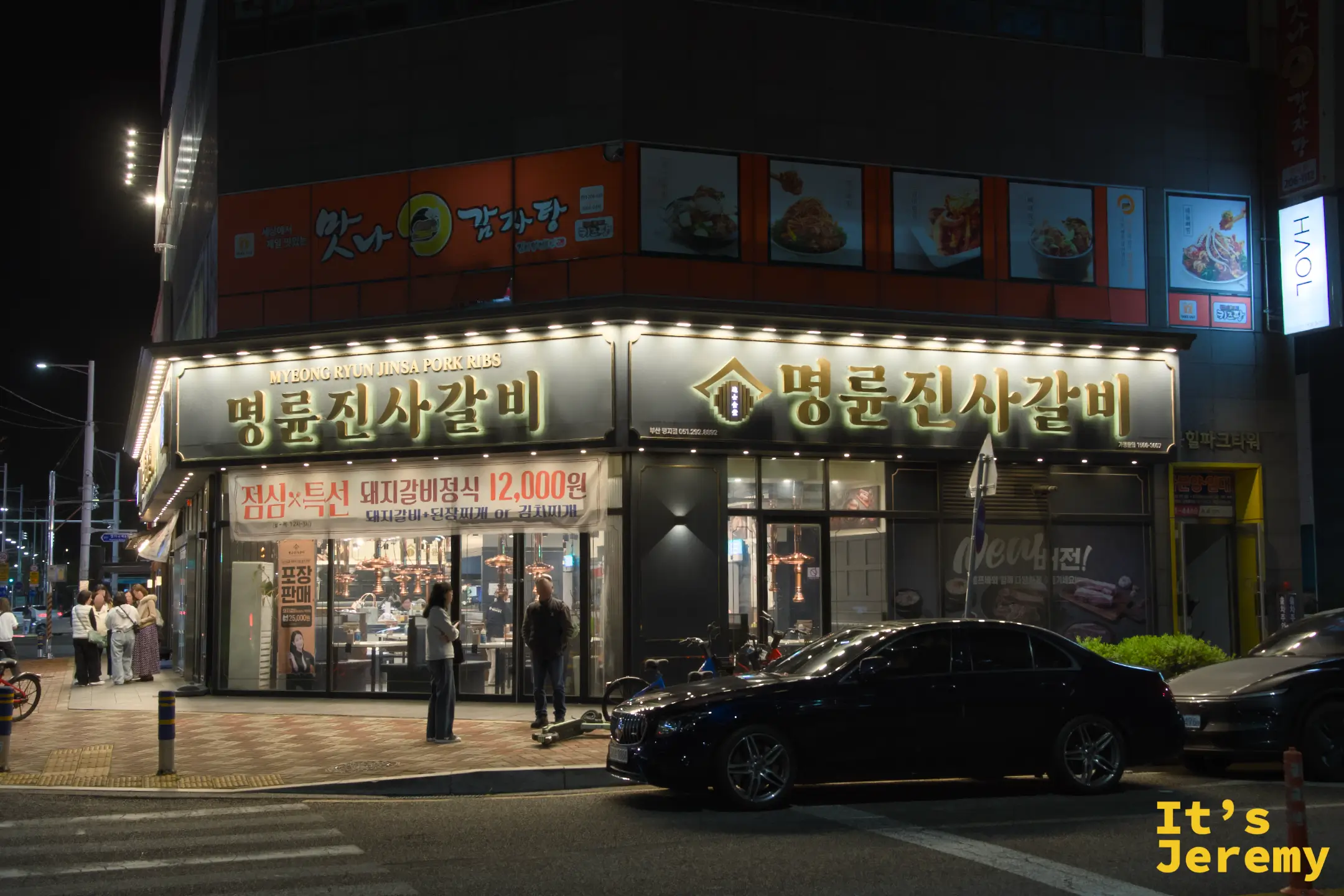 명륜진사갈비 명지점夜間外觀，招牌以金色大字打亮整個街角
