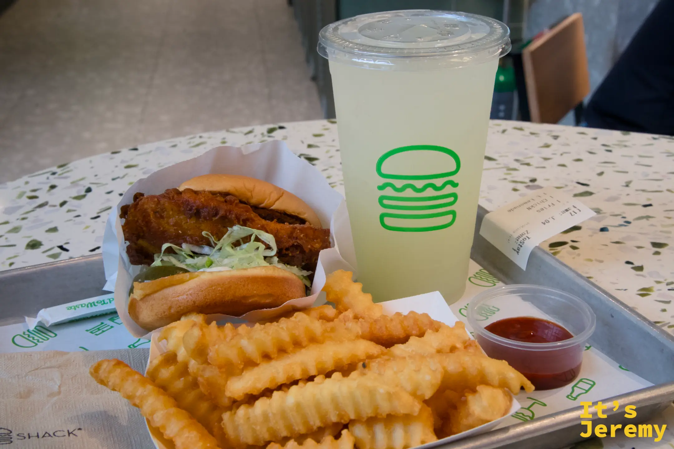 ChickN 雞肉堡、脆薯條、大杯 Lemonade，Shake Shack 標誌托盤，桌上有收據