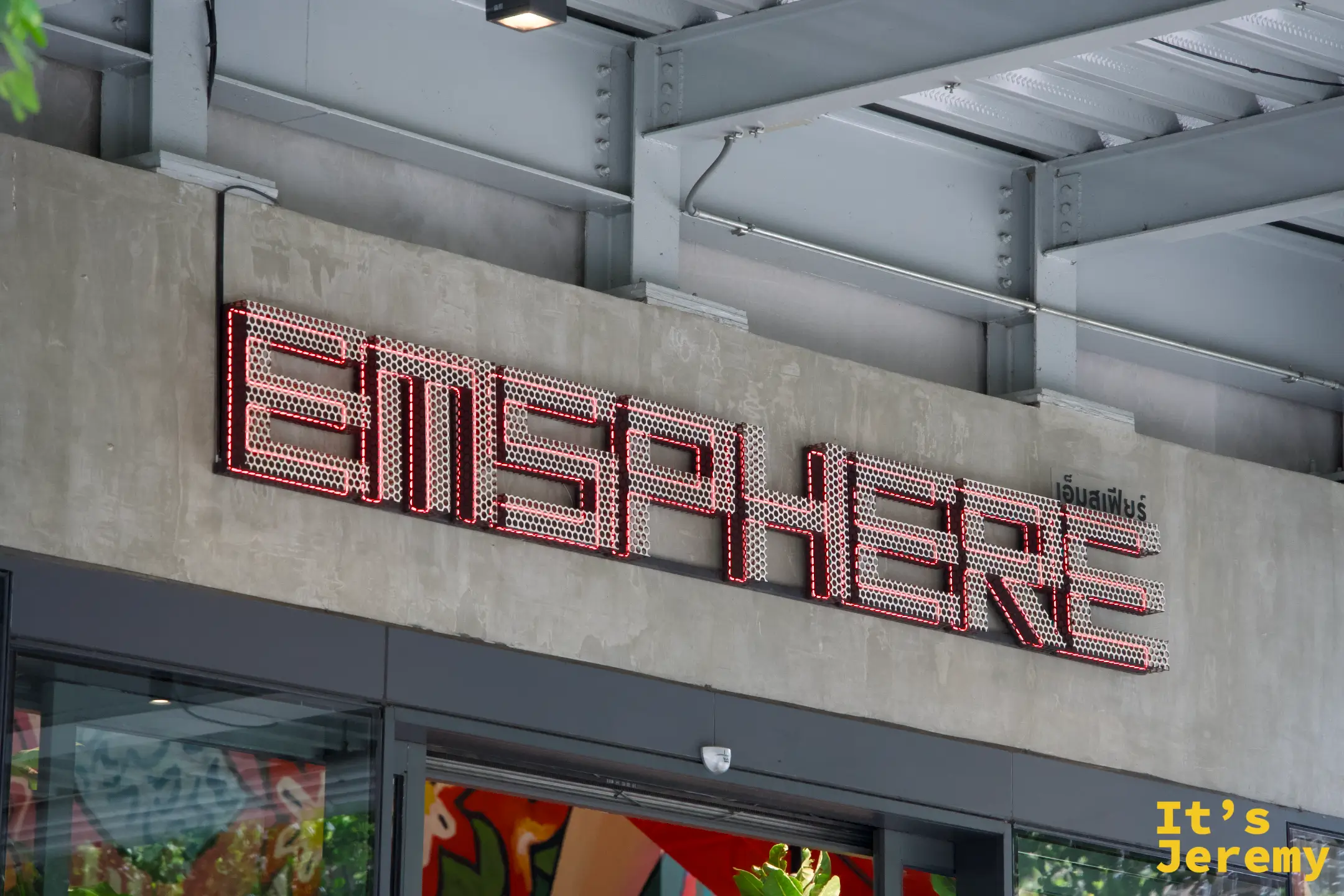 Emsphere 白天外觀，金屬網格字體招牌，泰文「อิมสเฟียร์」刻在水泥牆上
