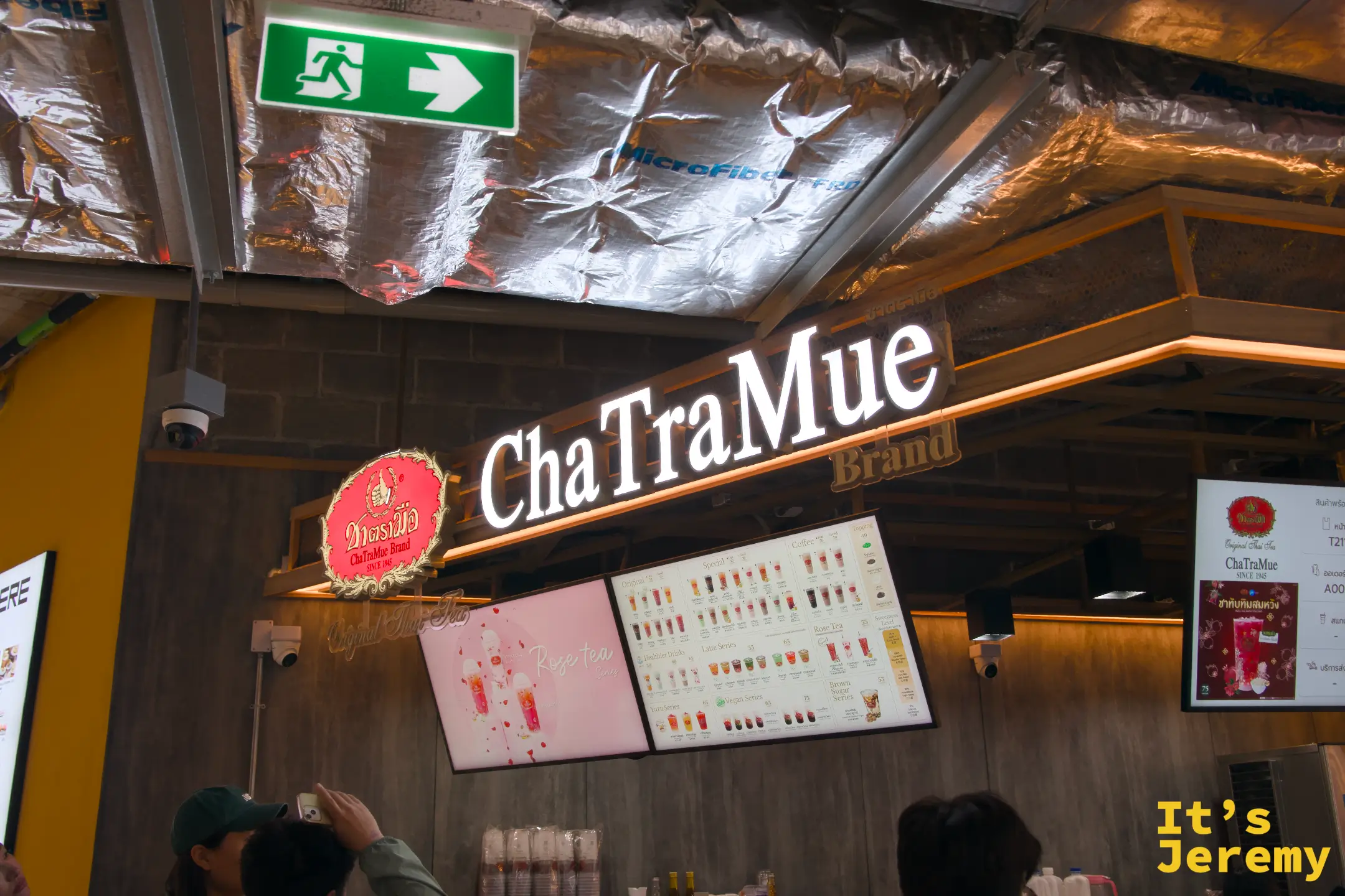 ChaTraMue 手標泰奶店攤位招牌,白色霓虹燈字,旁邊有飲品選單看板