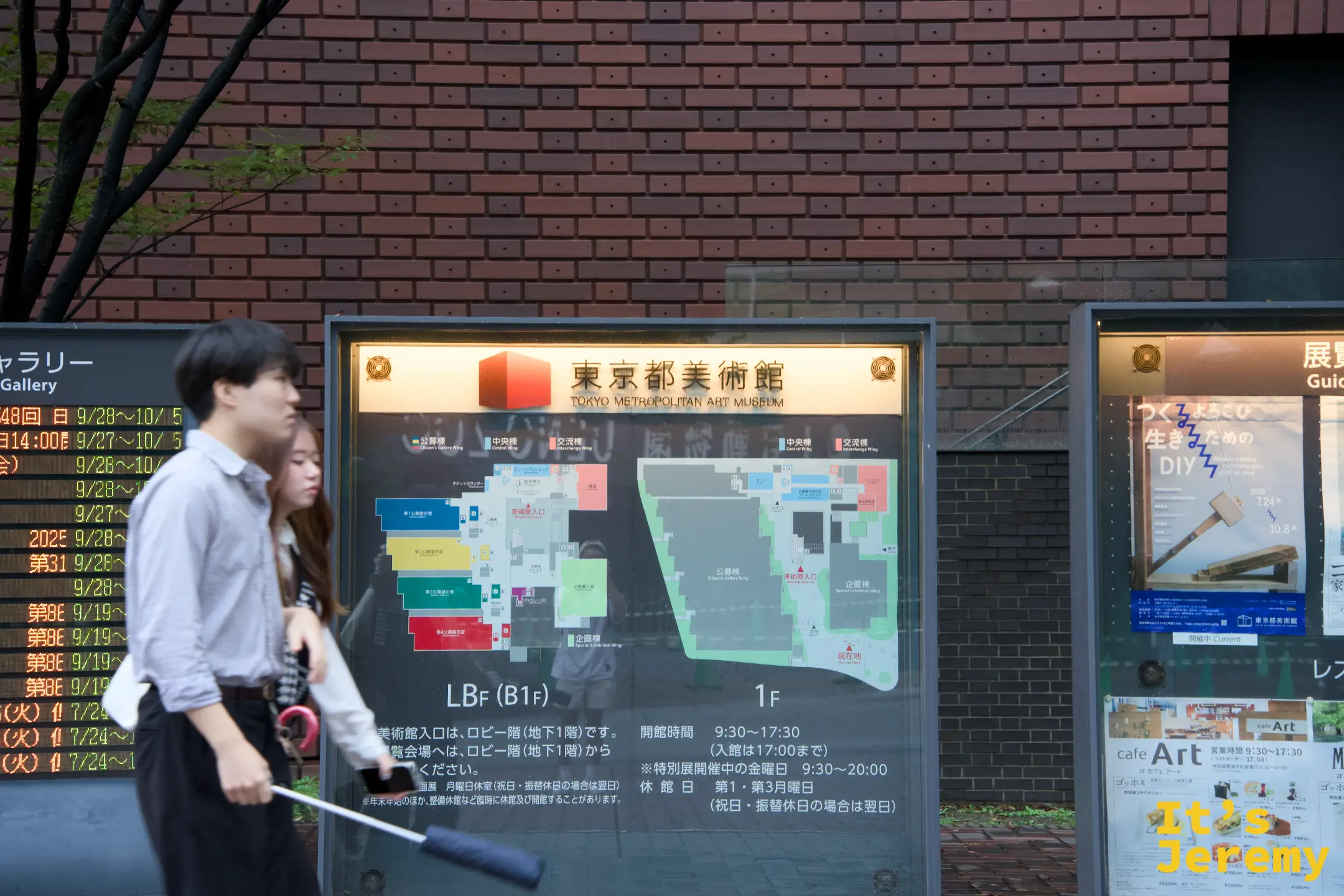 東京都美術館外的展覽告示牌,顯示館區地圖和開館時間,前方有行人路過,右側看板可見梵谷展的宣傳