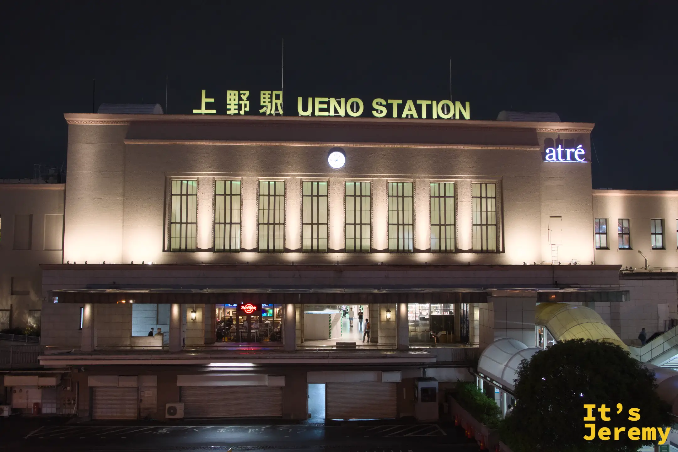 上野站夜間站體外觀,「上野駅 UENO STATION」金色大字在夜燈下清晰,atre 招牌亮著藍光,站前廣場安靜而有秩序