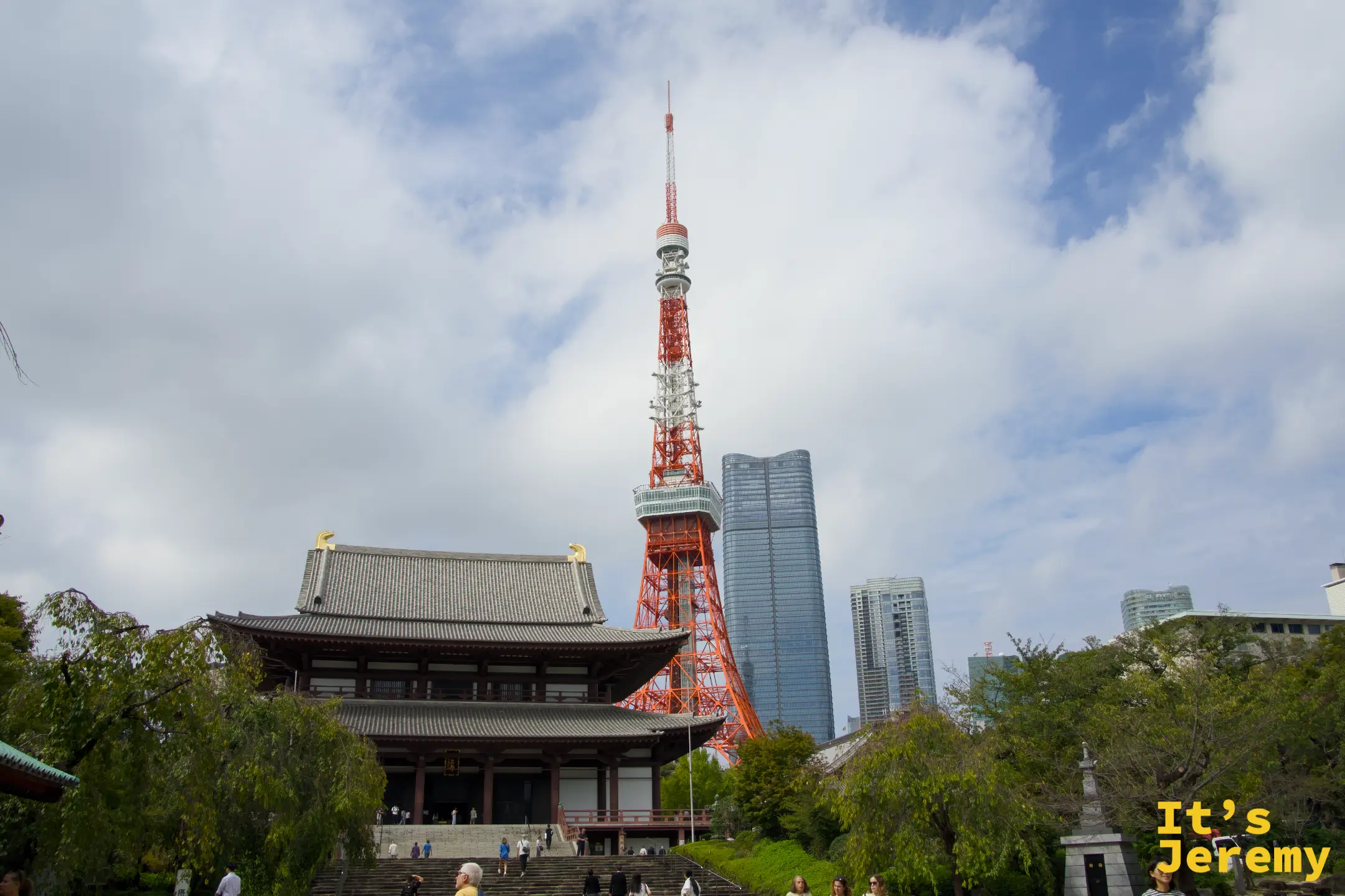 増上寺大殿正面，後方東京鐵塔聳立，台階前往來的遊客