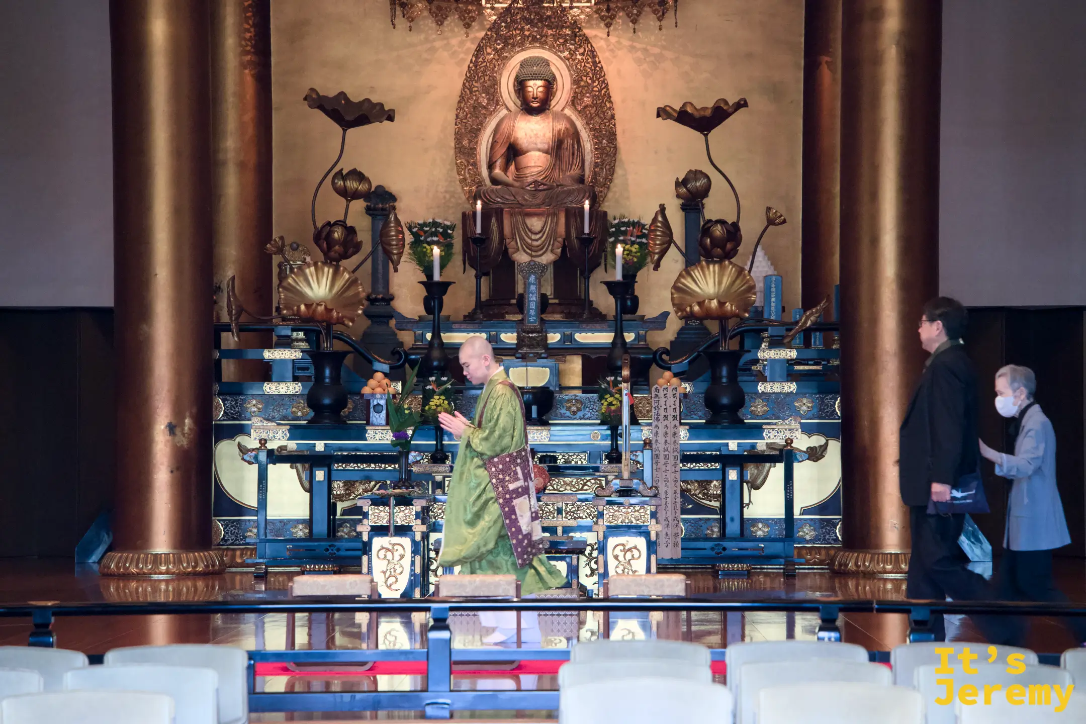 増上寺大殿內,僧侶身著黃綠法袍在金色佛壇前緩步行走