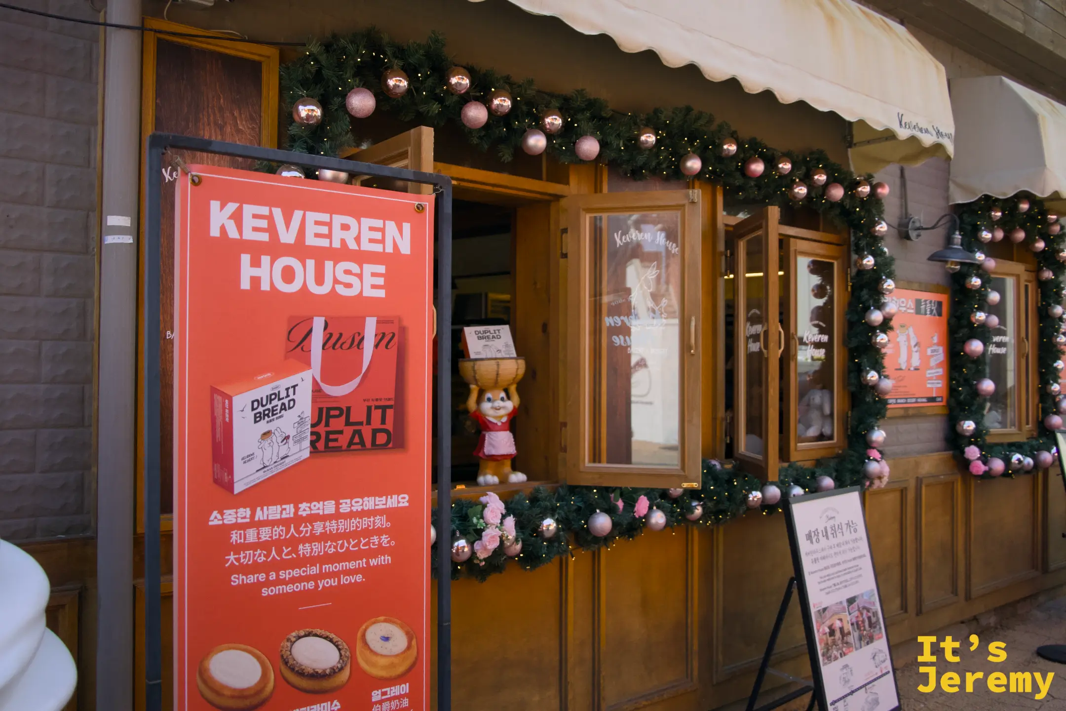 鮮橘色立牌正面標示 KEVEREN HOUSE 與 DUPLIT BREAD 品項介紹，聖誕花圈裝飾讓門口自成一個拍照景點