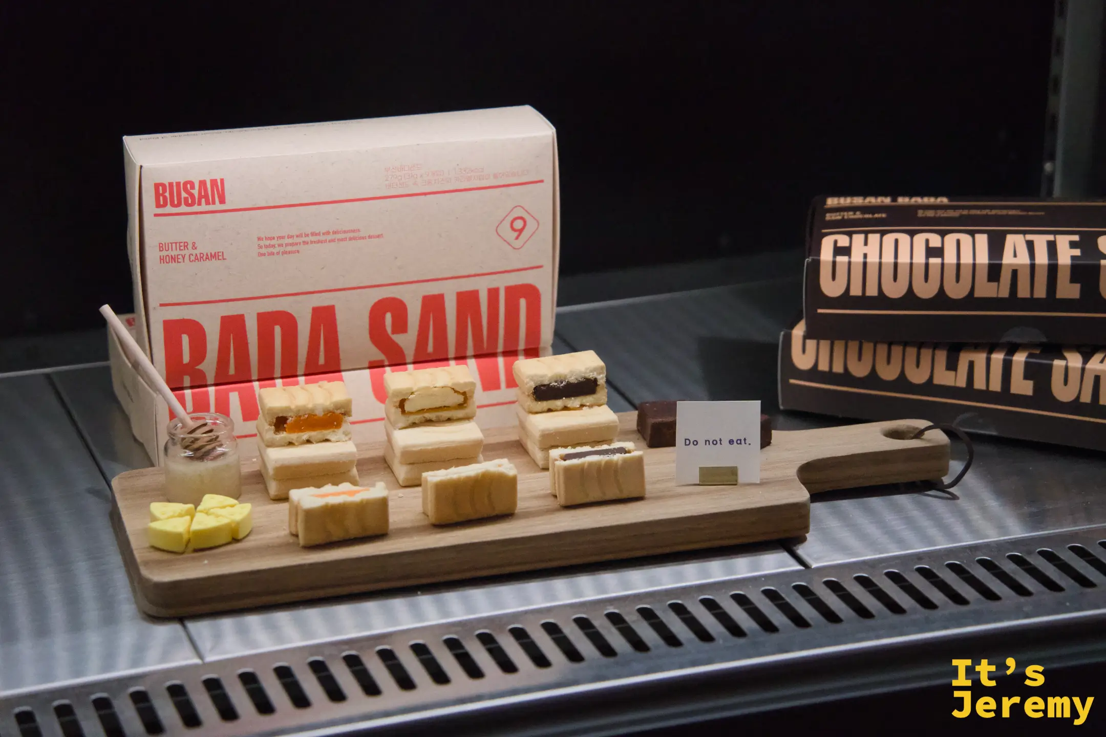 展示木板上陳列 Butter & Honey Caramel 與 Chocolate Sand 的剖面模型，後方是正式包裝盒