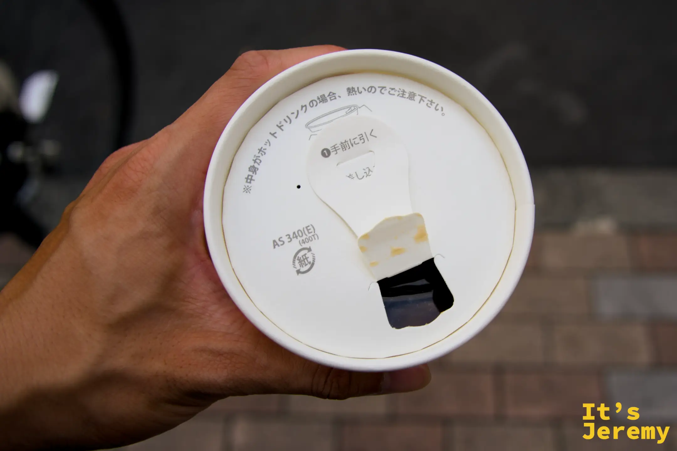 外帶杯蓋俯視,淡淡的咖啡痕跡透過白色杯蓋呈現