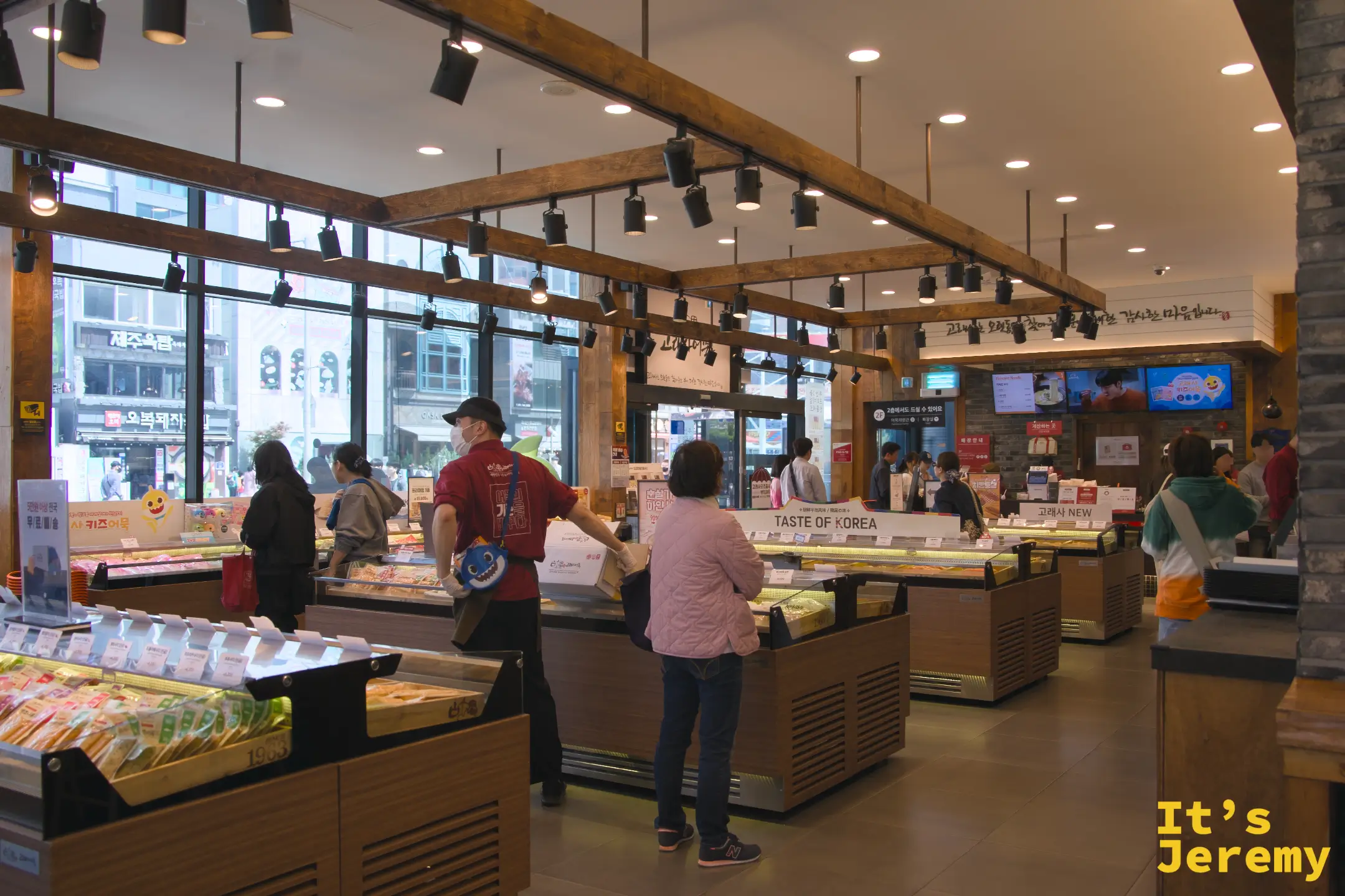 古來思魚板海雲台店室內全景，木質樑柱、暖光陳列台與多個魚板展示區