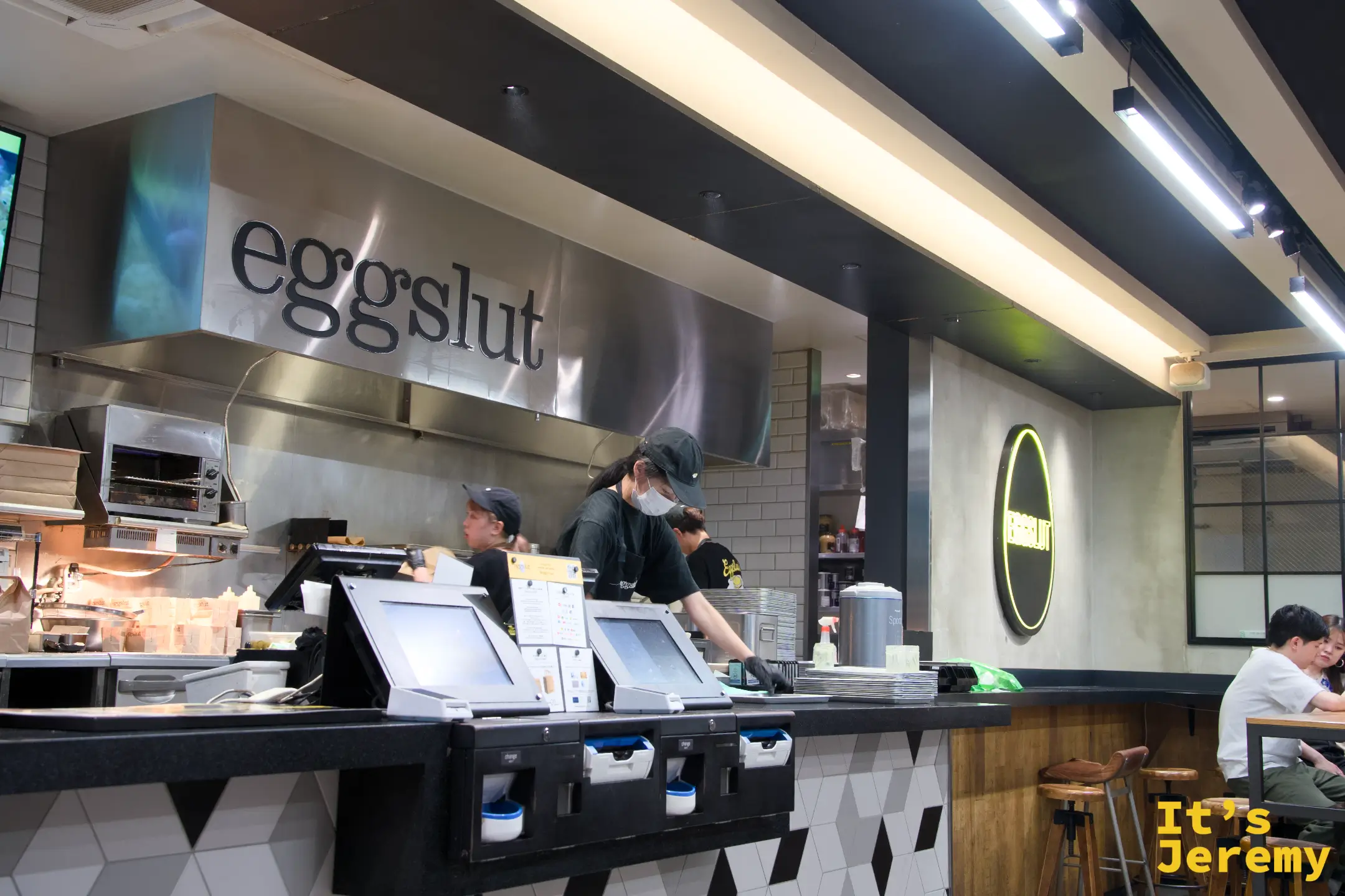 eggslut 店內廚房吧台,員工正在備料,eggslut 字樣在牆上