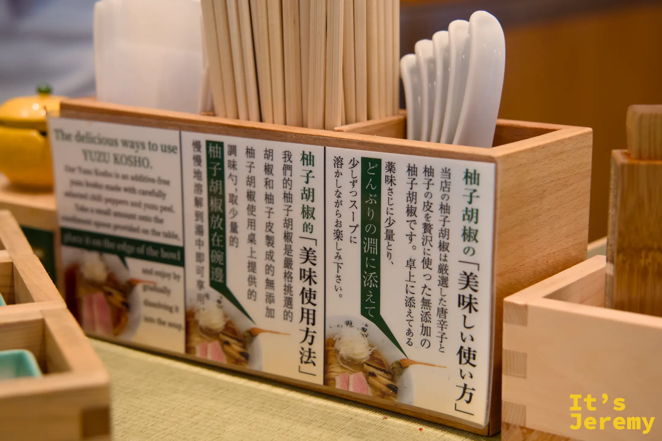 桌上的柚子胡椒說明牌，旁邊擺著一個完整柚子和筷架湯匙架