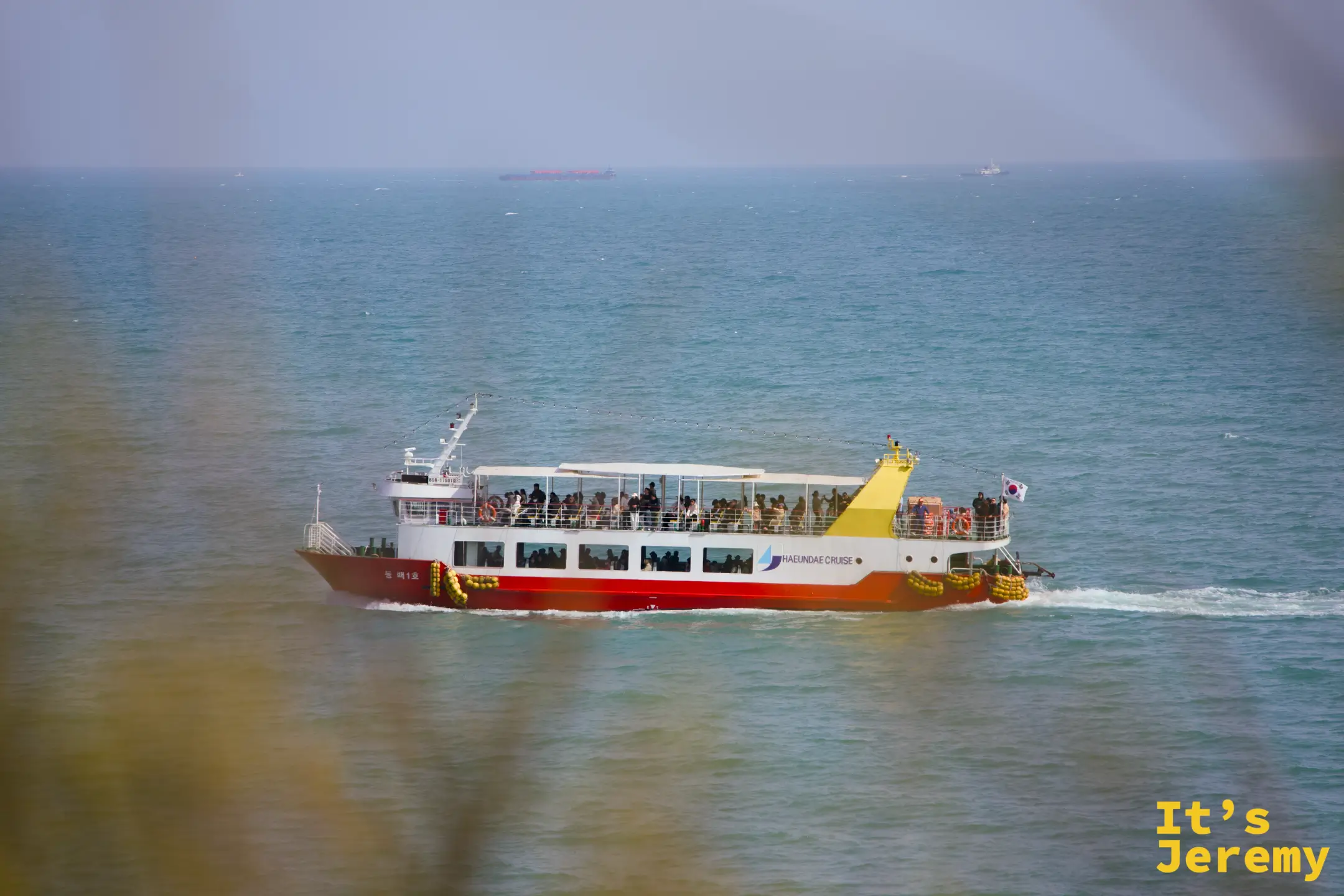 海雲臺觀光遊覽船從冬柏島外海駛過，韓國國旗飄揚在船尾