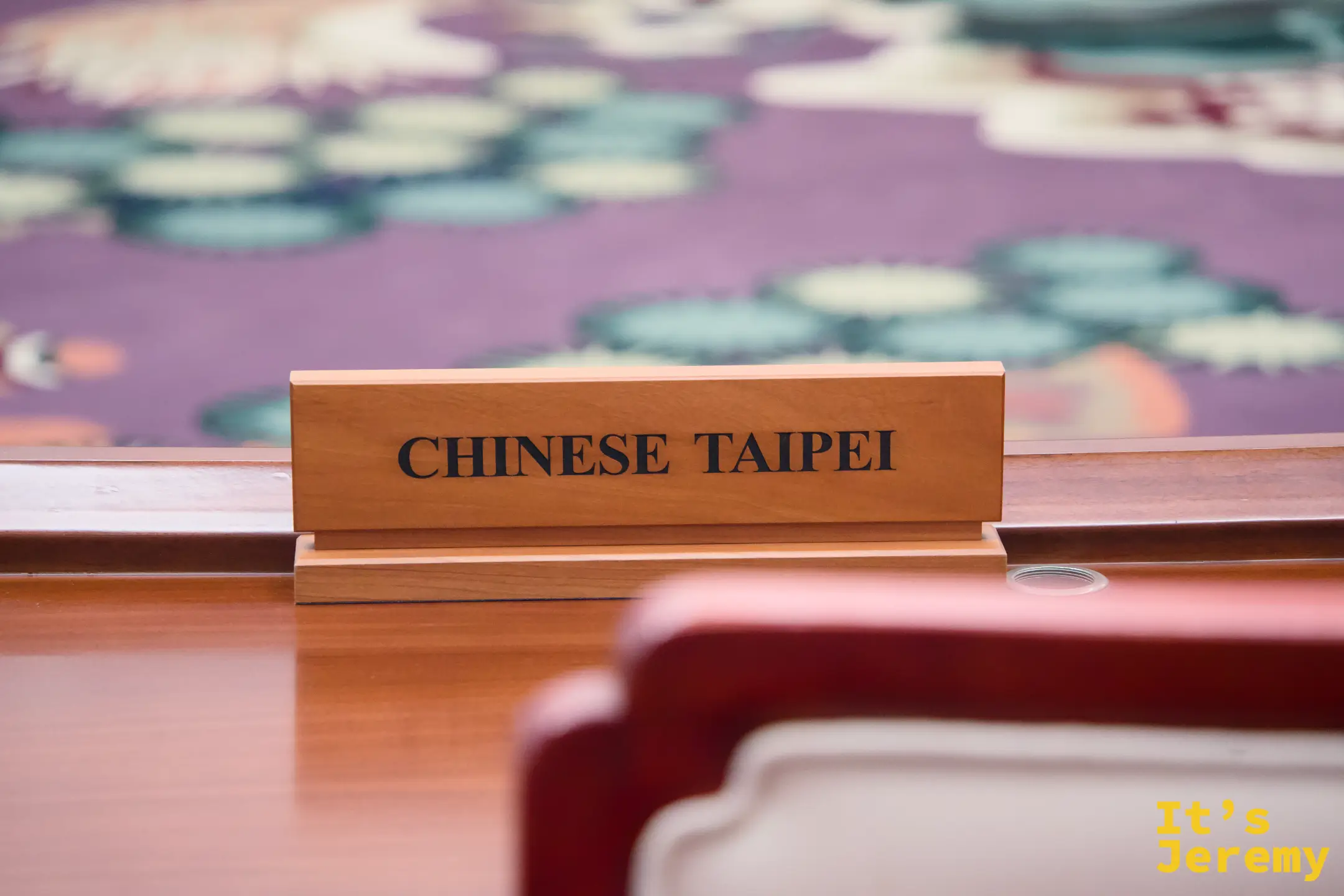 APEC 會議廳圓桌近景，刺繡地毯細節清晰，CHINESE TAIPEI 名牌特寫