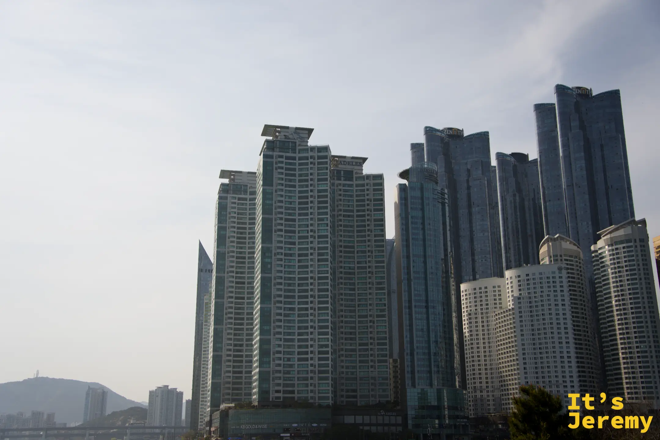 從冬柏島眺望釜山海雲臺 Marine City 密集的玻璃帷幕高樓群，與步道的礁石自然形成強烈對比